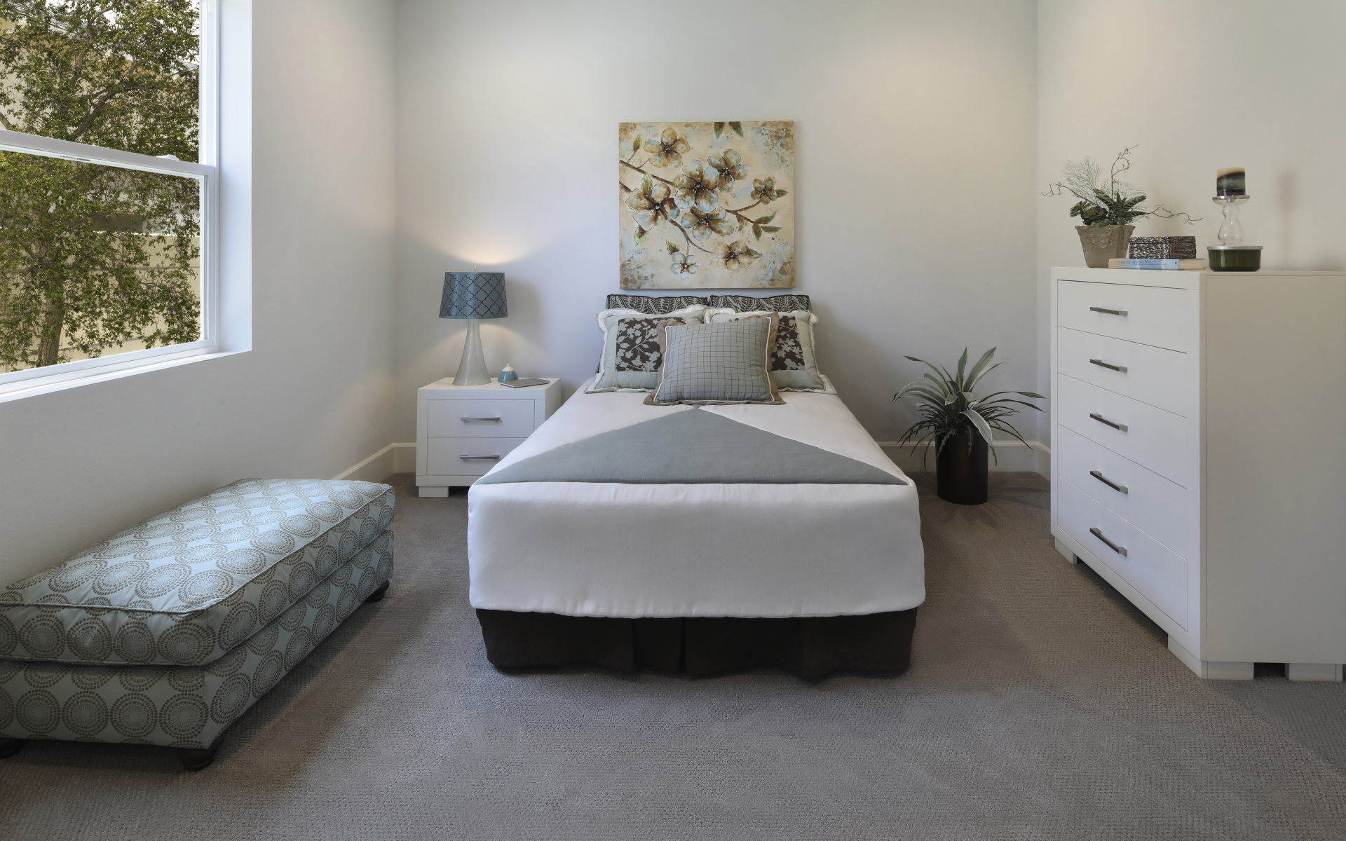 Спальная комната с кроватью и мягкой лежанкой у окна 