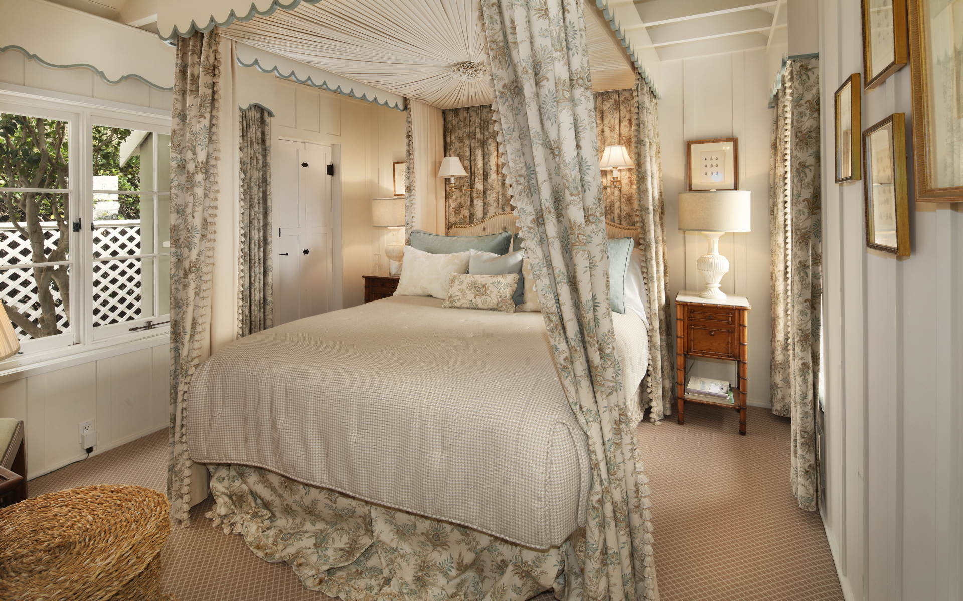 Высокая кровать с занавесками в спальной комнате в пастельных тонах 