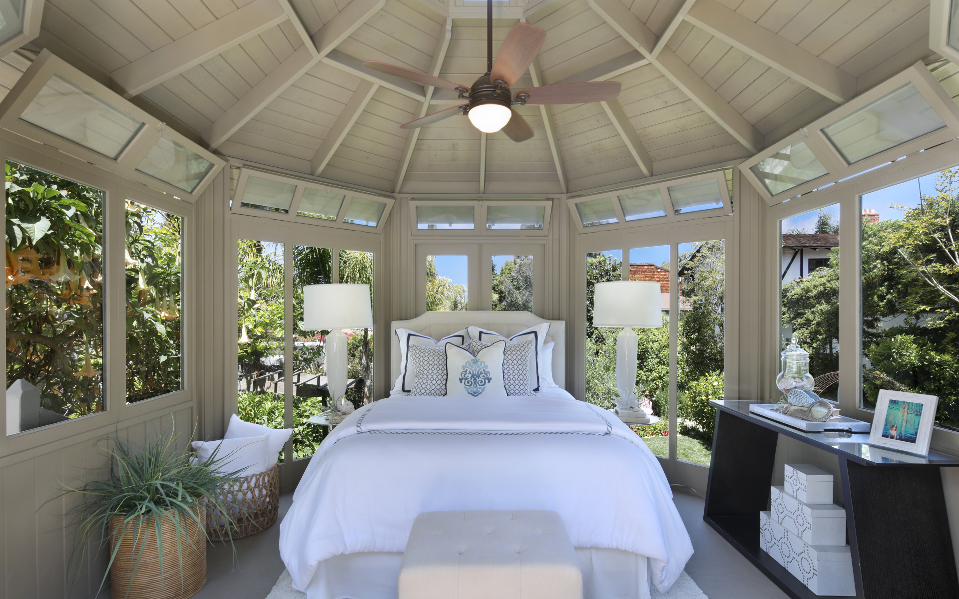 Большая спальная комната с окнами и белой кроватью 