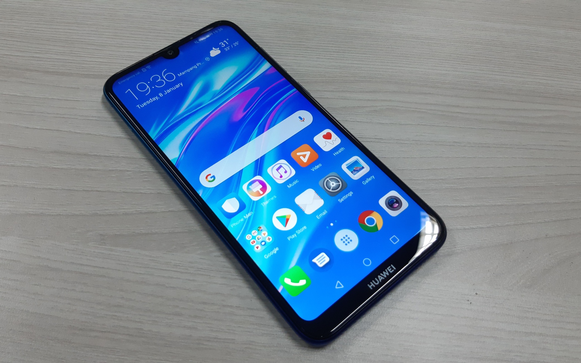 Смартфон Huawei Y7 Pro, 2019 года лежит на деревянном столе