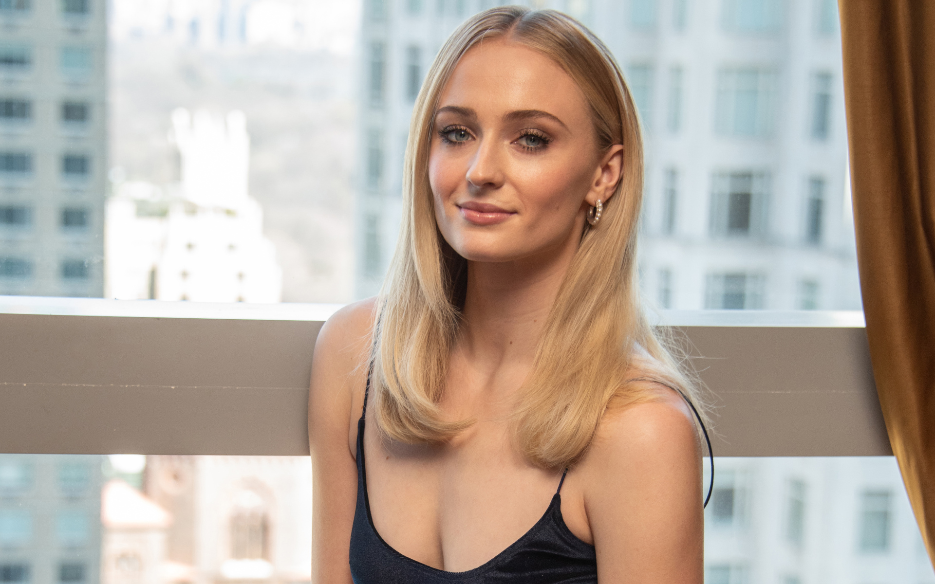 Стильная красивая блондинка, актриса Софи Тёрнер у окна