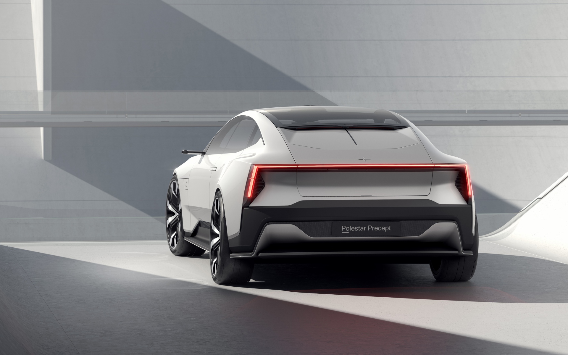 Серебристый автомобиль Polestar Precept 2020 года на фоне серой стены