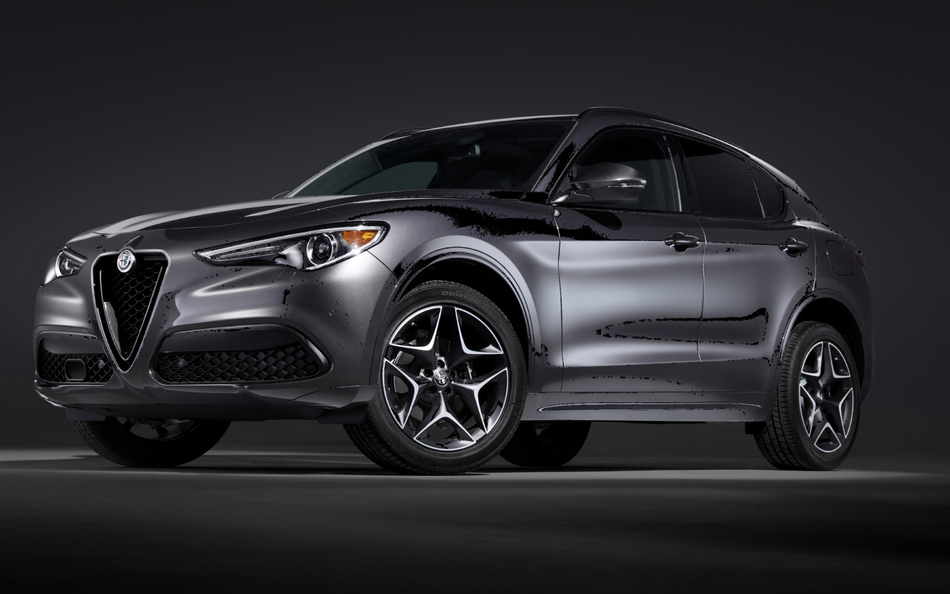 Серебристый автомобиль Alfa Romeo, 2020 года на сером фоне