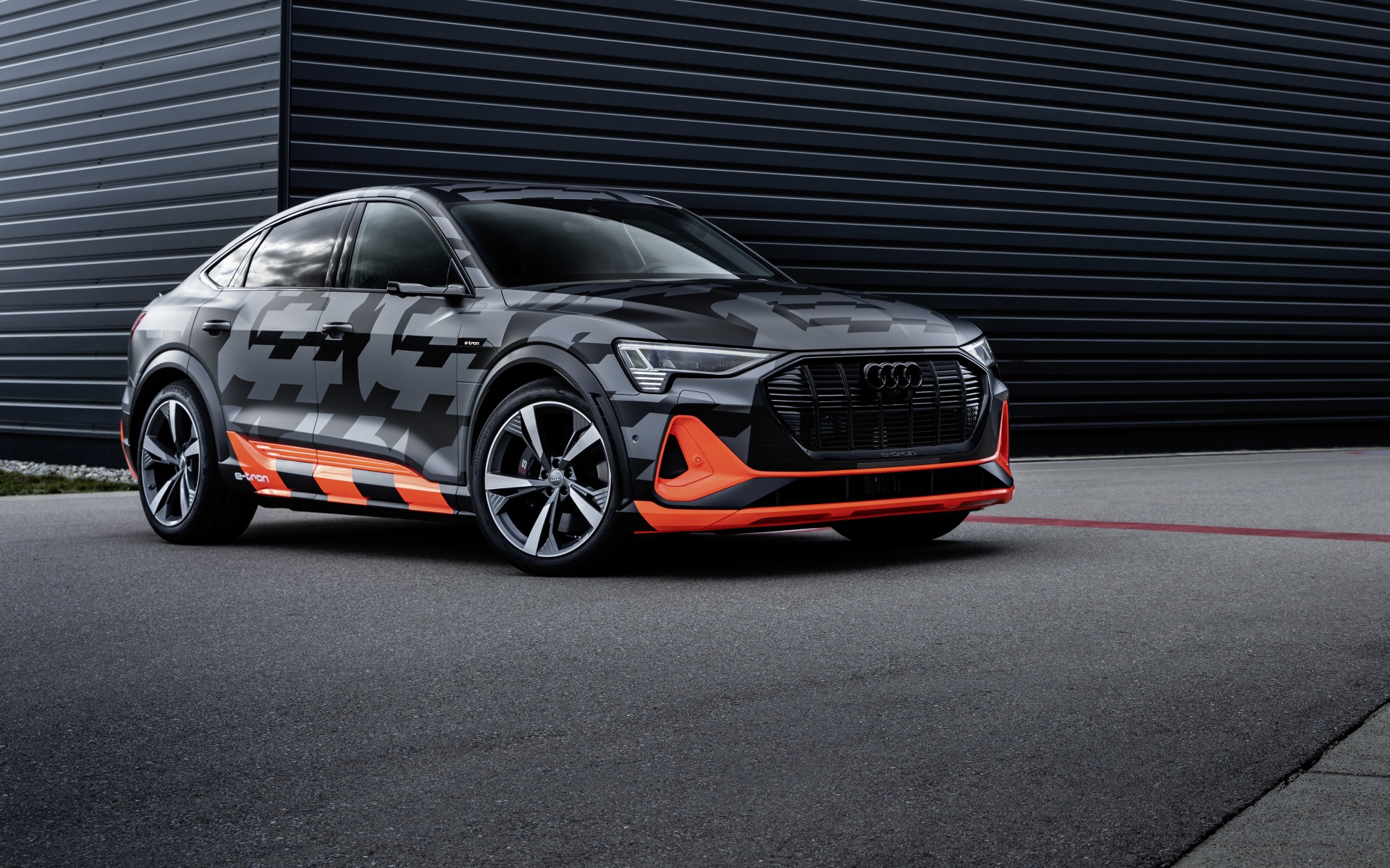 Автомобиль Audi E-Tron S Sportback Prototype 2020 года на фоне черной стены 