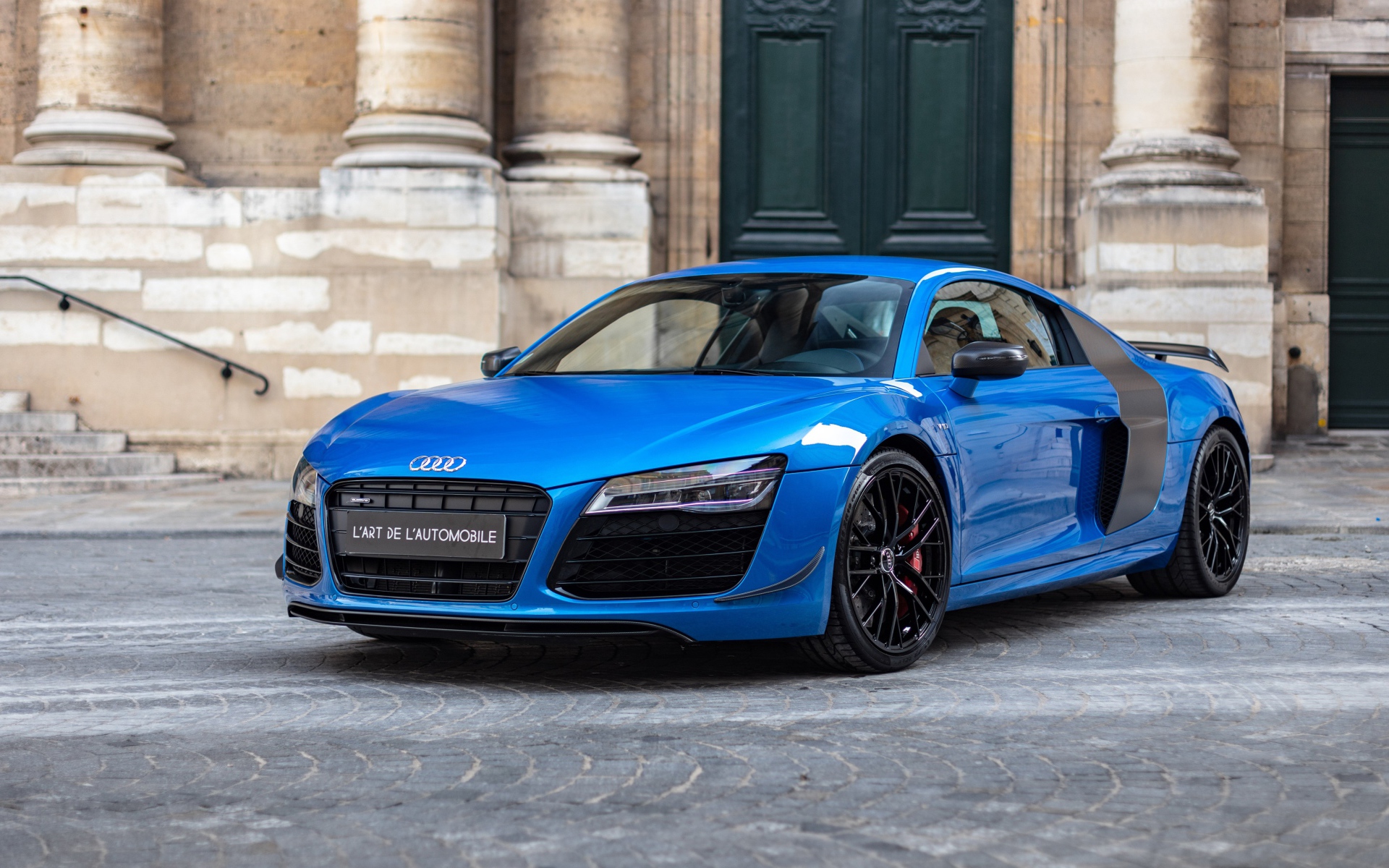 Синий автомобиль Audi R8 LMX у старого здания