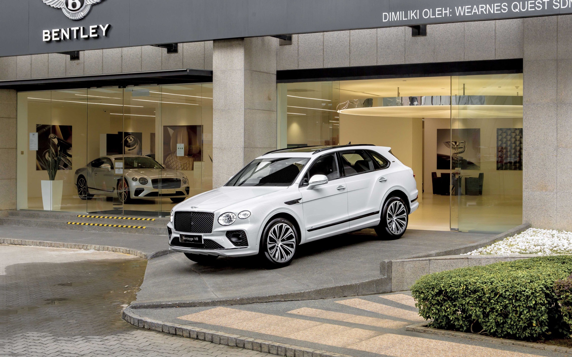 Белый автомобиль Bentley Bentayga V8 First Edition 2020 года выезжает из автосалона 