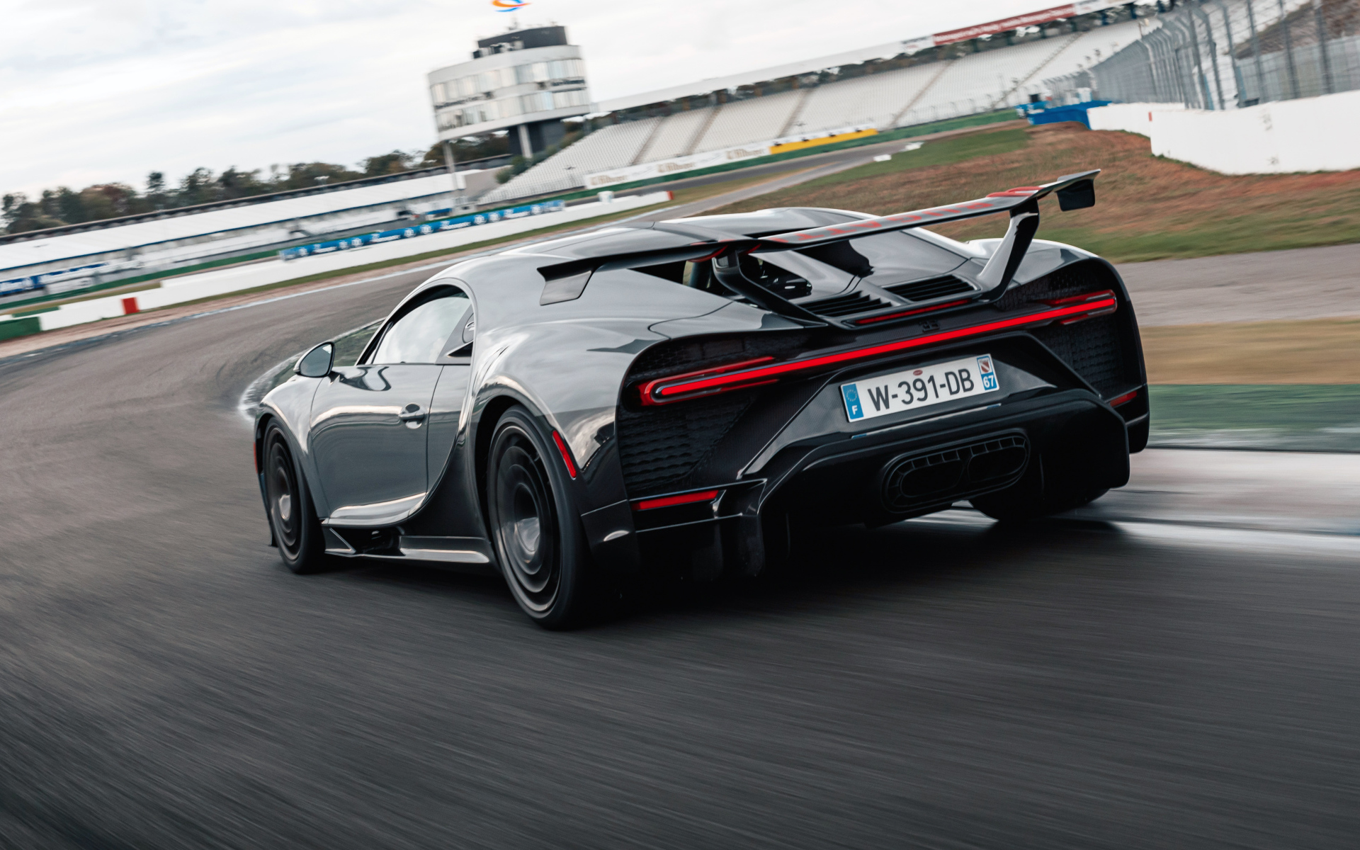 Черный быстрый автомобиль Bugatti Chiron Pur Sport 2020 года на стадионе