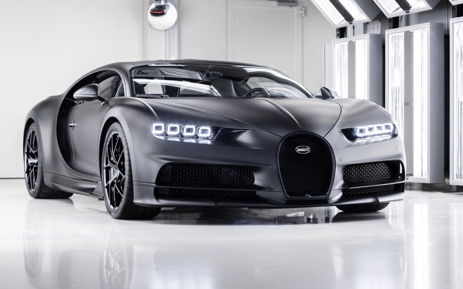 Автомобиль bugatti chiron 2020 года с включенными фарами