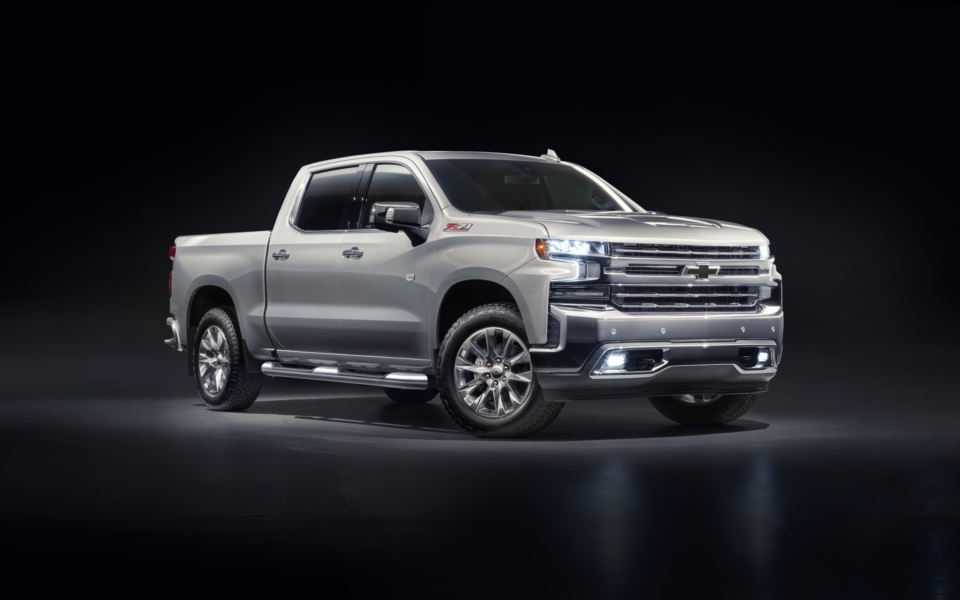 Серебристый автомобиль Chevrolet Silverado 1500 LTZ Z71 Premium Edition 2020 года на черном фоне