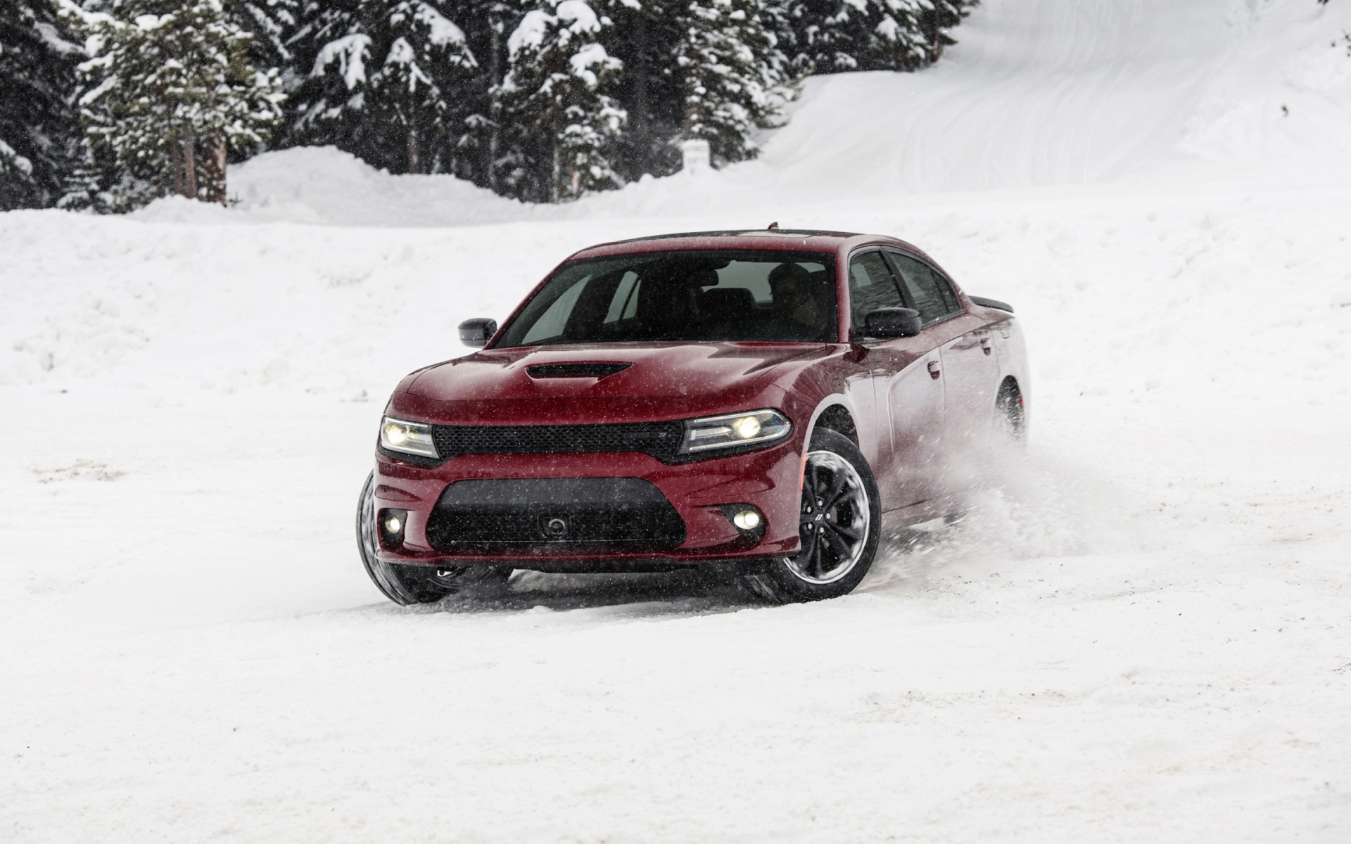 Красный автомобиль  Dodge Charger GT AWD, 2020 года едет по снегу