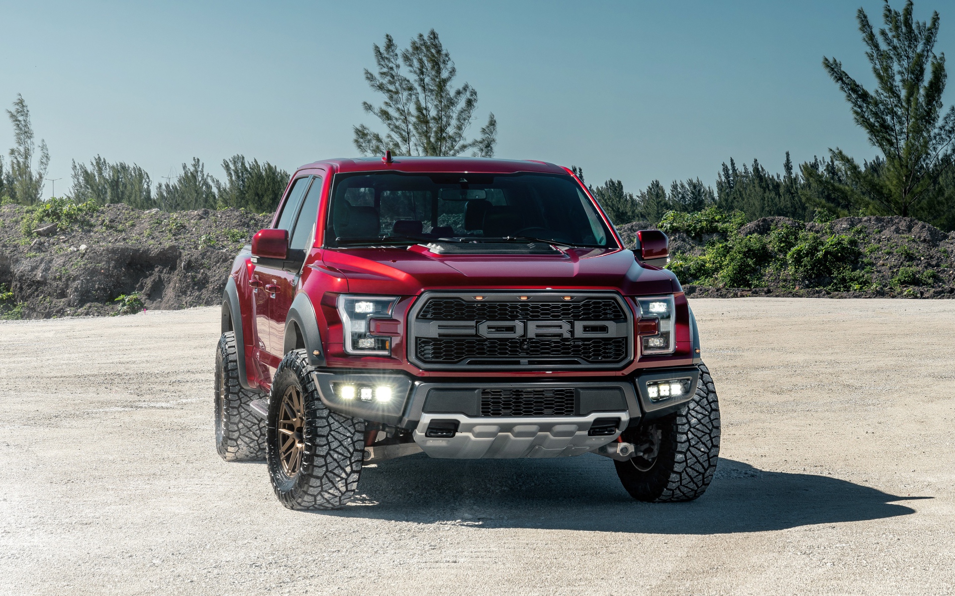 Красный внедорожник Ford F-150 Raptor на песке