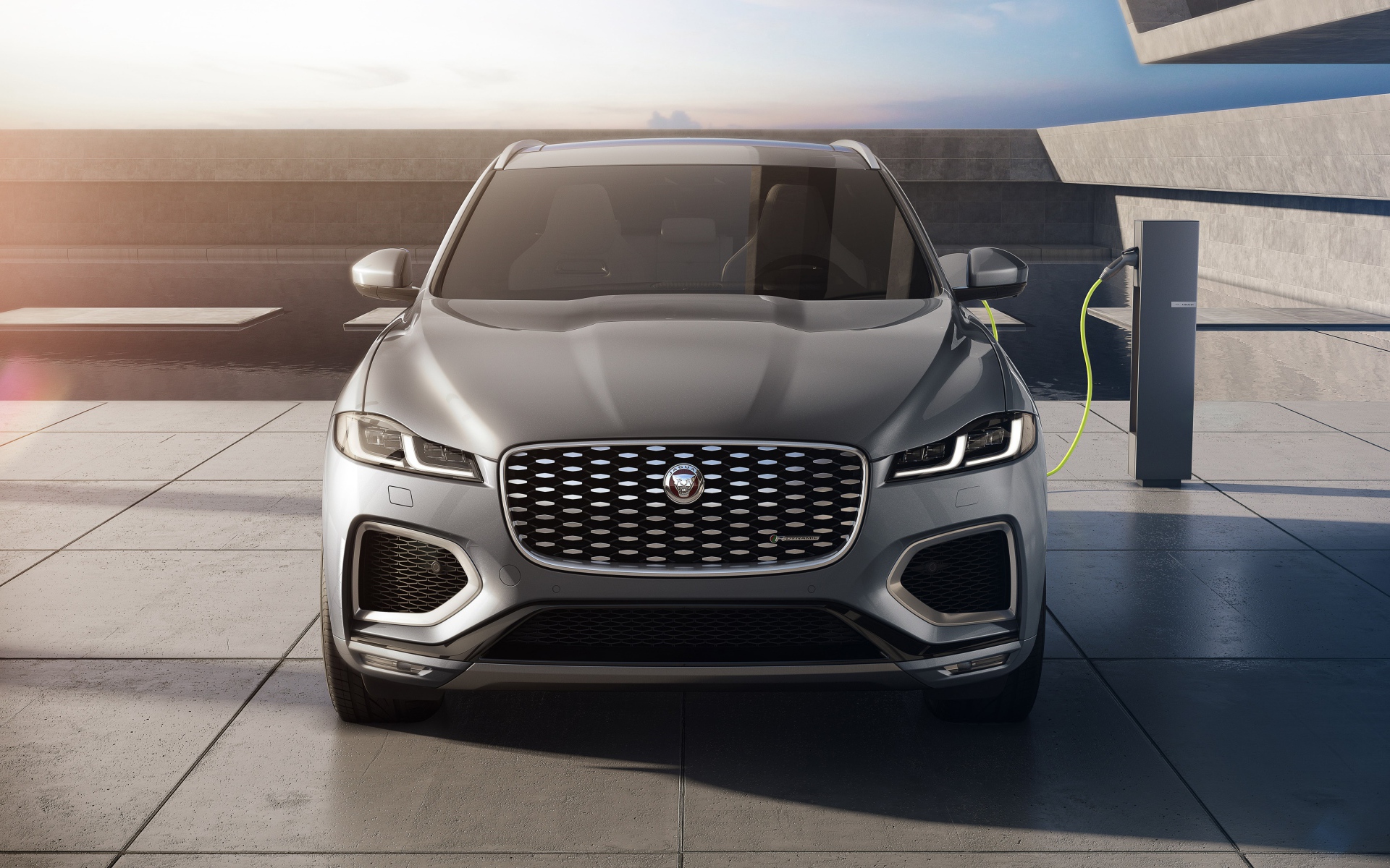 Серый автомобиль Jaguar F-Pace P400e AWD 2020 года на заправке