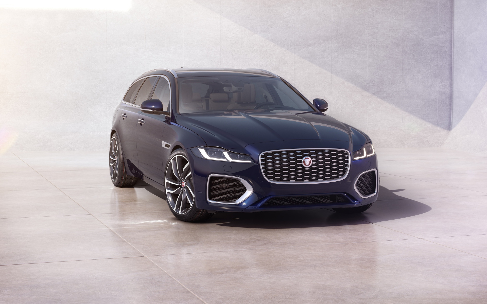 Синий автомобиль Jaguar XF Sportbrake 2020 года у стены 