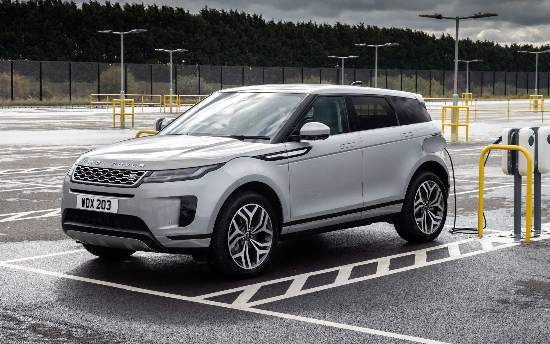 Серебристый автомобиль Range Rover Evoque P300e S 2020 года на заправке