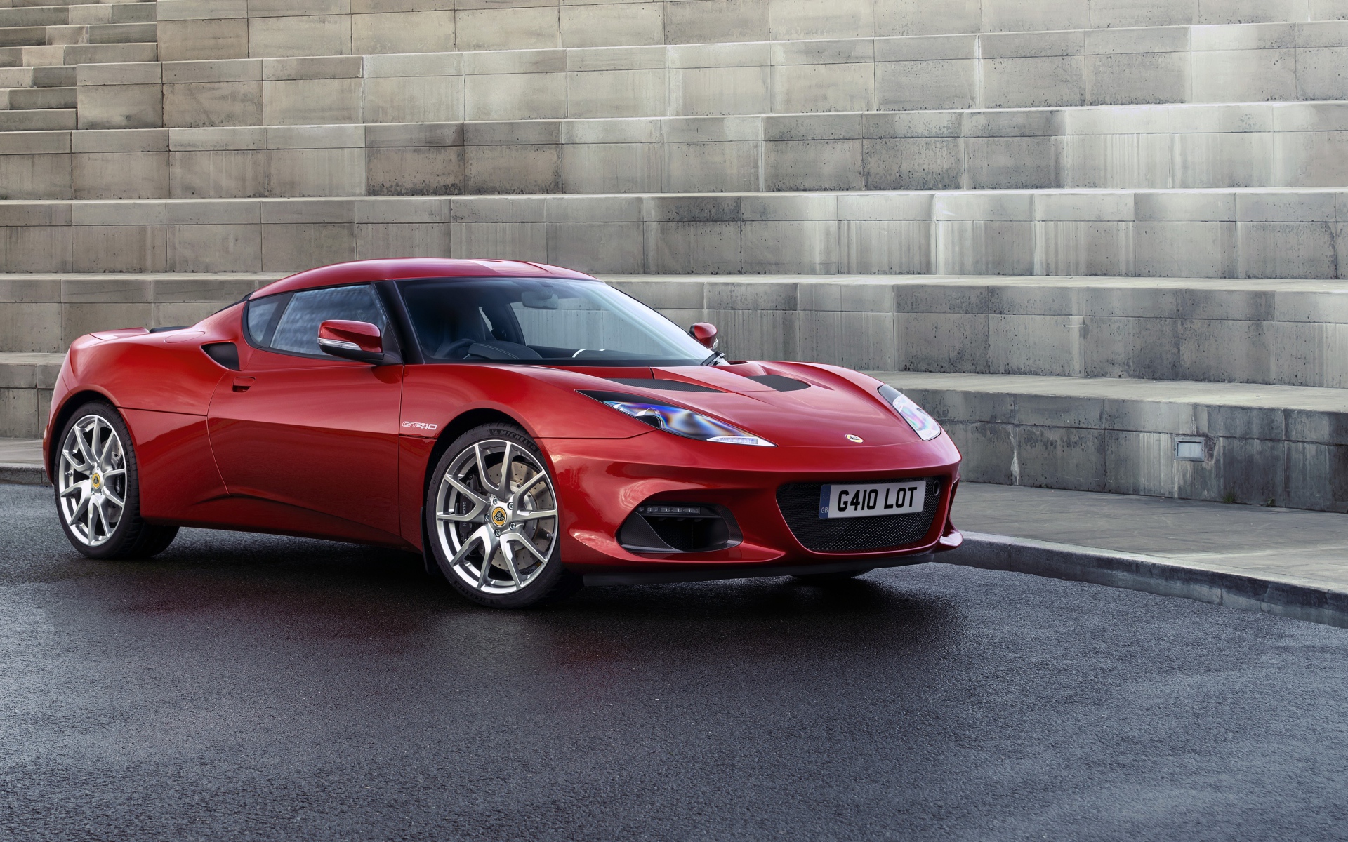 Быстрый красный автомобиль Lotus Evora GT410 2020 года у ступенек 
