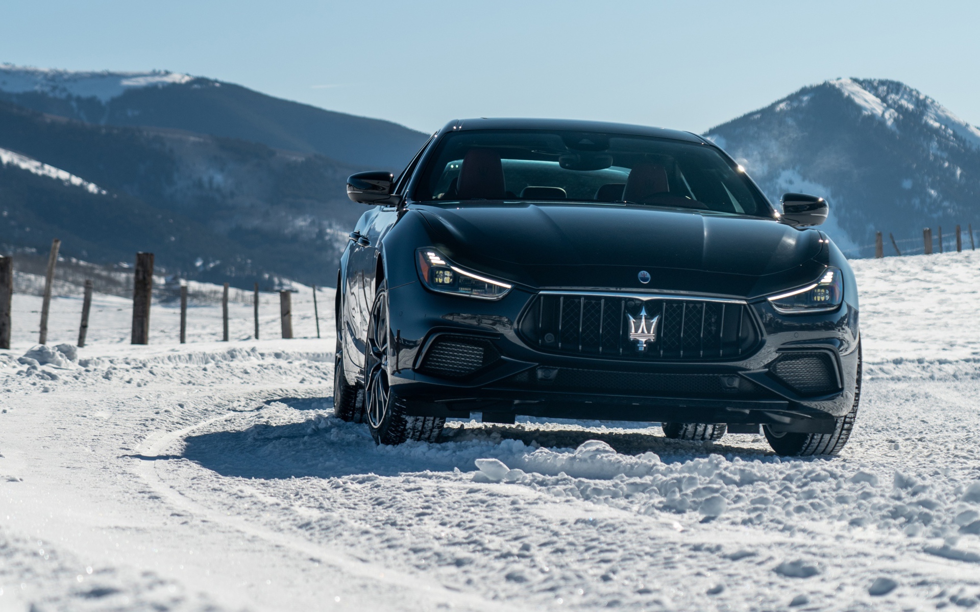 Черный автомобиль Maserati Ghibli S Q4, 2020 года едет по заснеженной дороге