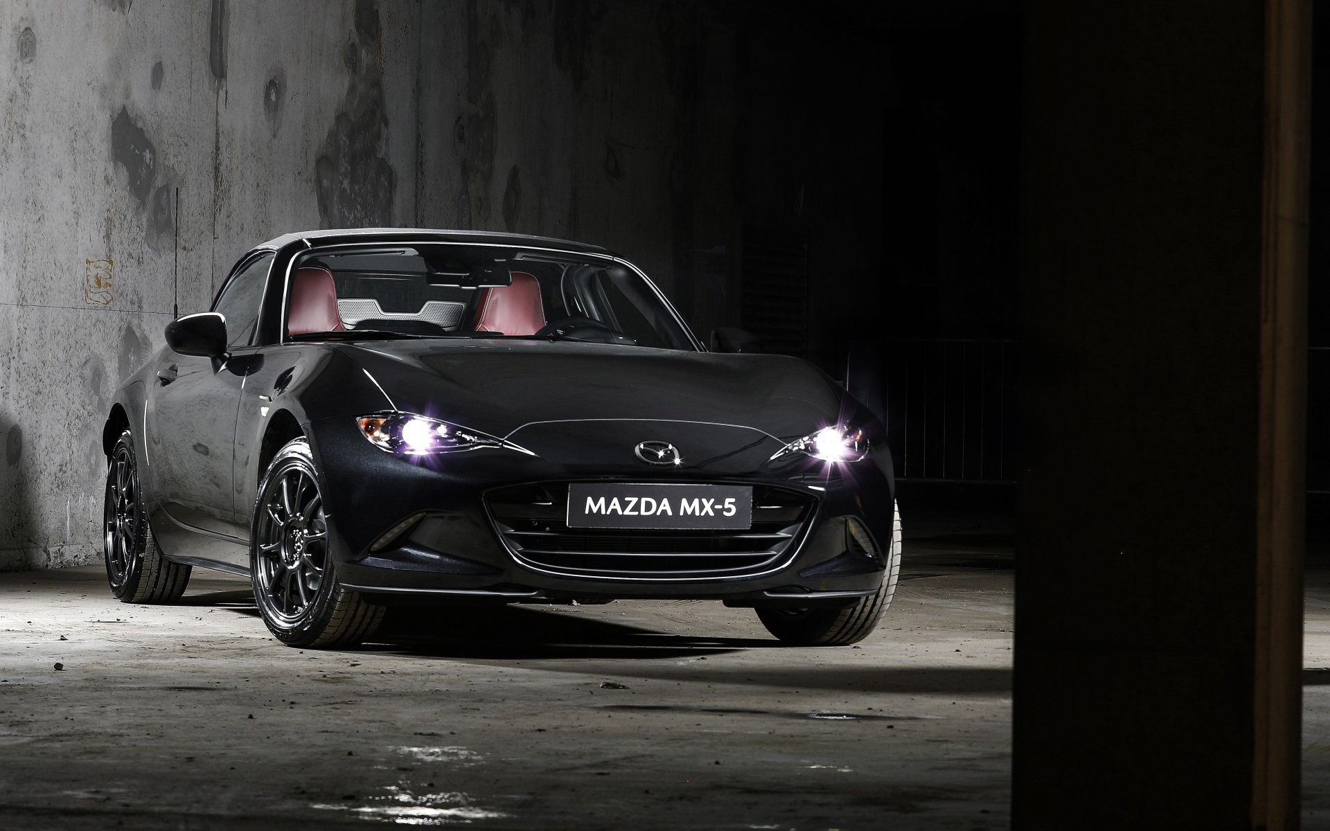 Черный автомобиль Mazda MX-5 Eunos Edition 2020 года с включенными фарами