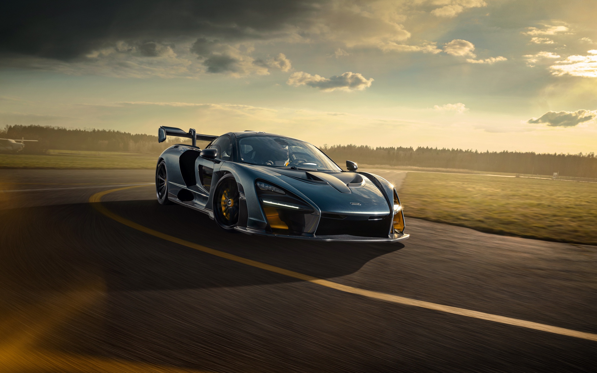 Гоночный автомобиль  McLaren Senna 2020 года на фоне заката 