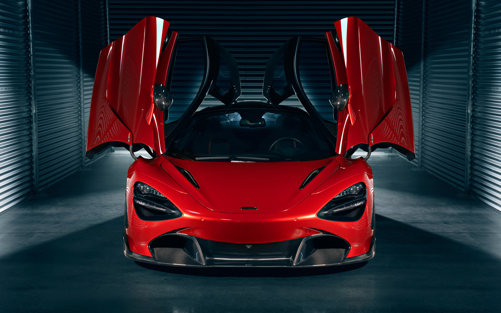 Красный автомобиль McLaren 720S с открытыми дверями в гараже