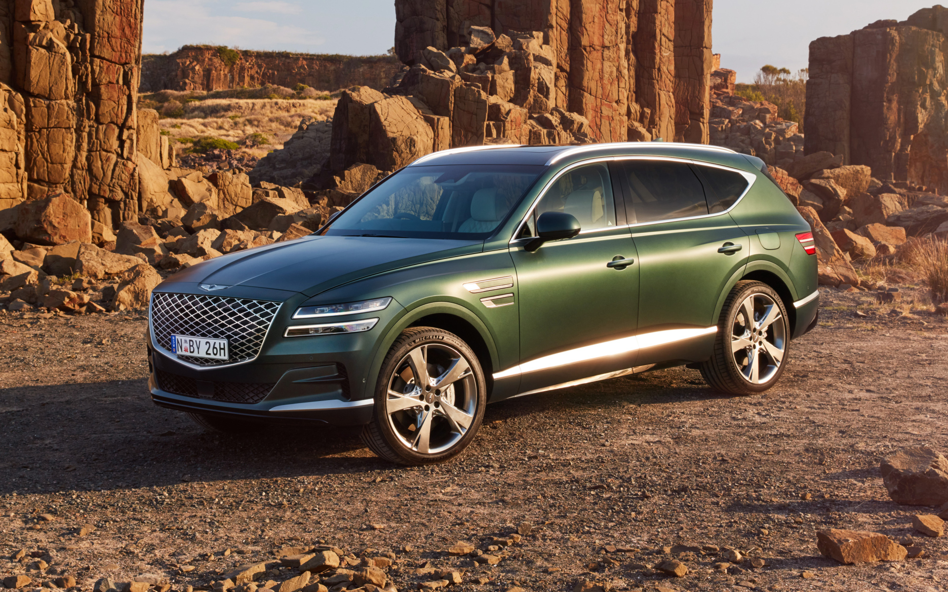 Зеленый автомобиль Genesis GV80 3.5T AWD 2020  года в горах