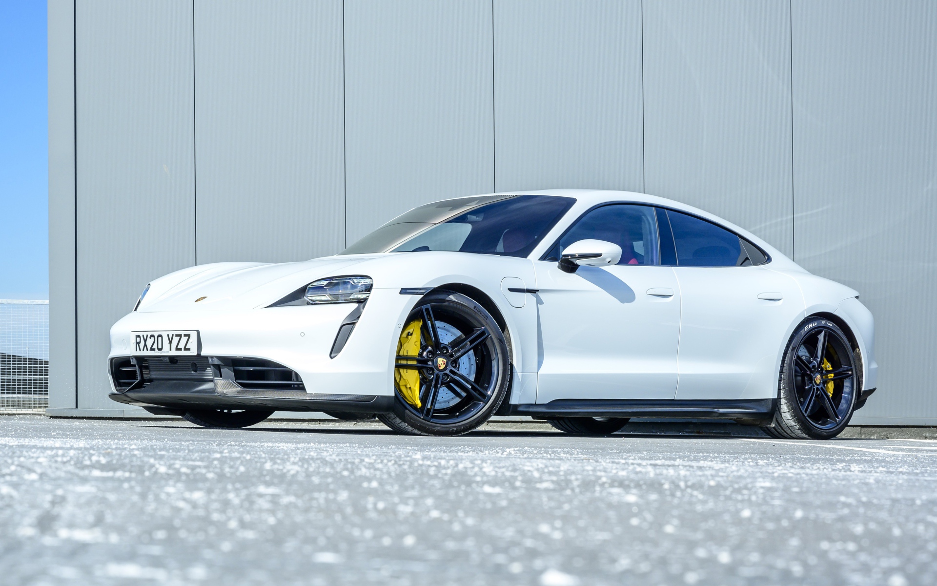 Белый автомобиль Porsche Taycan Turbo S 2020 года в лучах солнца 