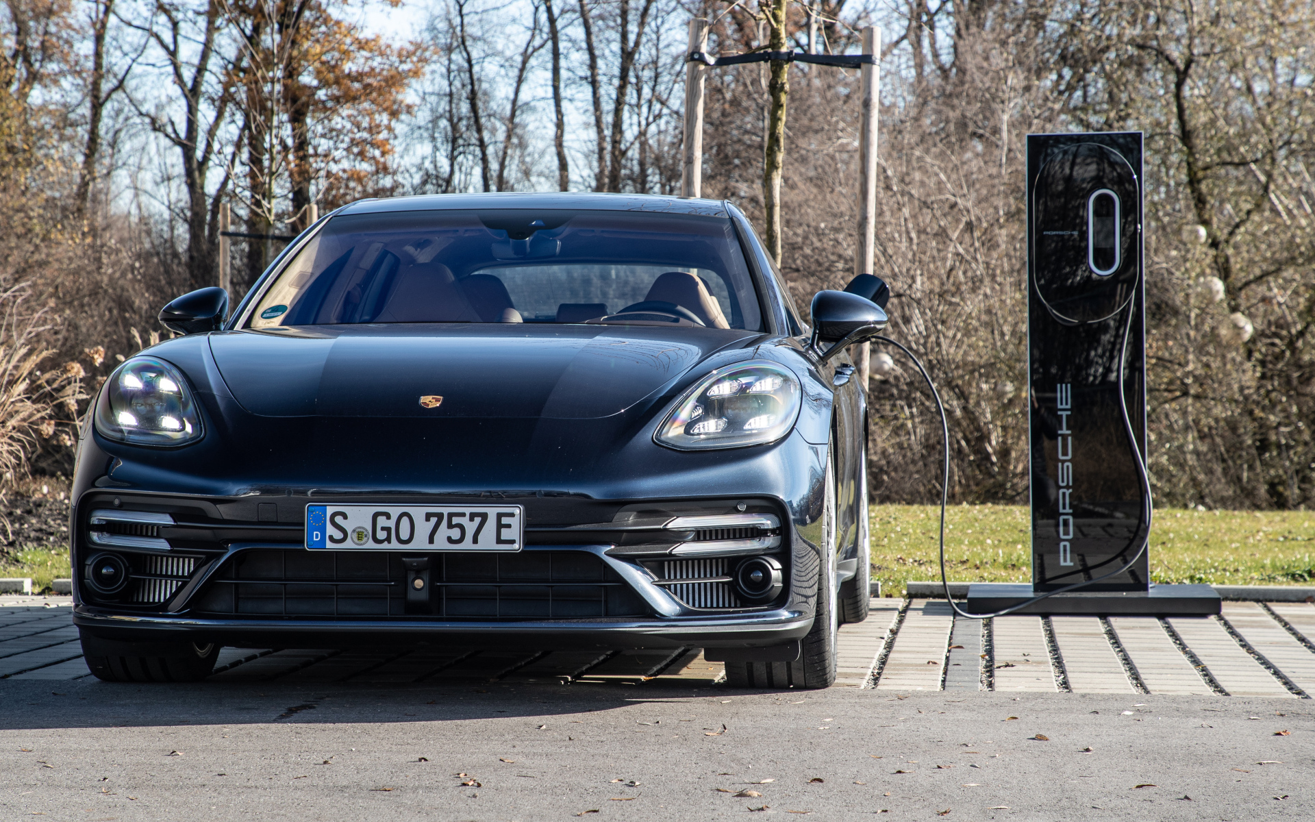 Черный автомобиль Porsche Panamera Turbo S E-Hybrid Sport Turismo 2021 года на заправке