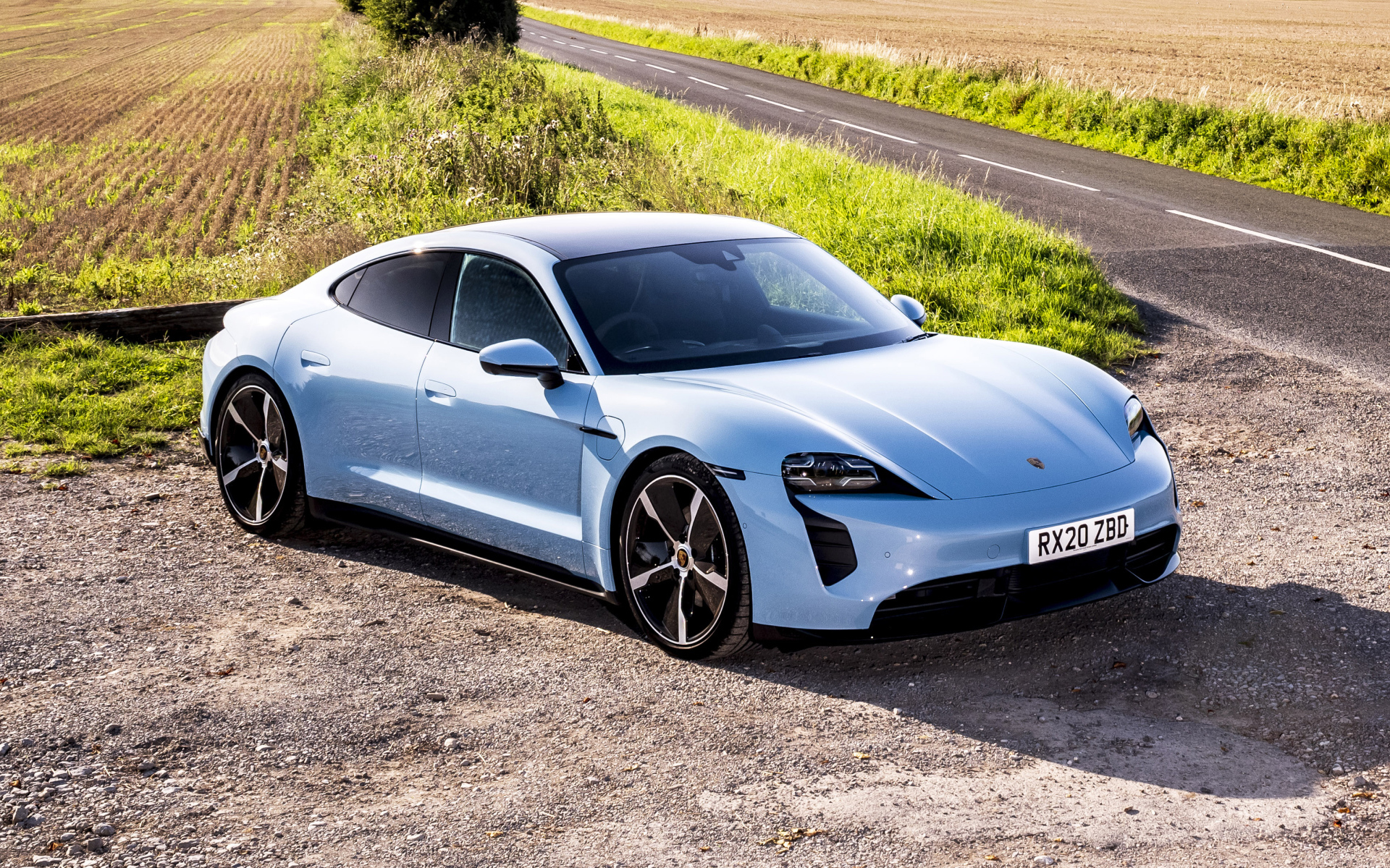 Быстрый автомобиль Porsche Taycan 4S 2021 года на фоне поля