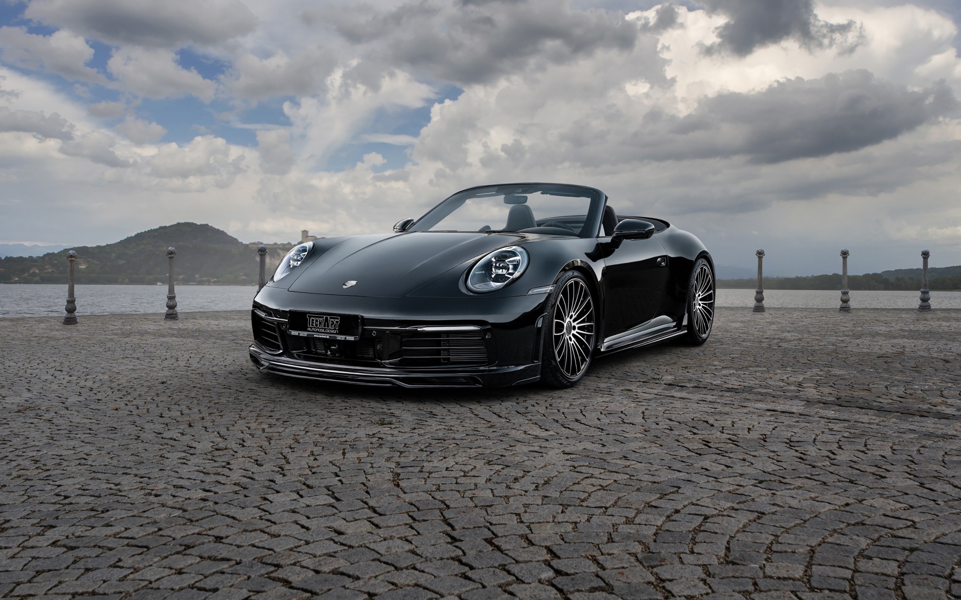 Черный кабриолет  Porsche 911 Carrera 4S, 2020 года на фоне грозового неба