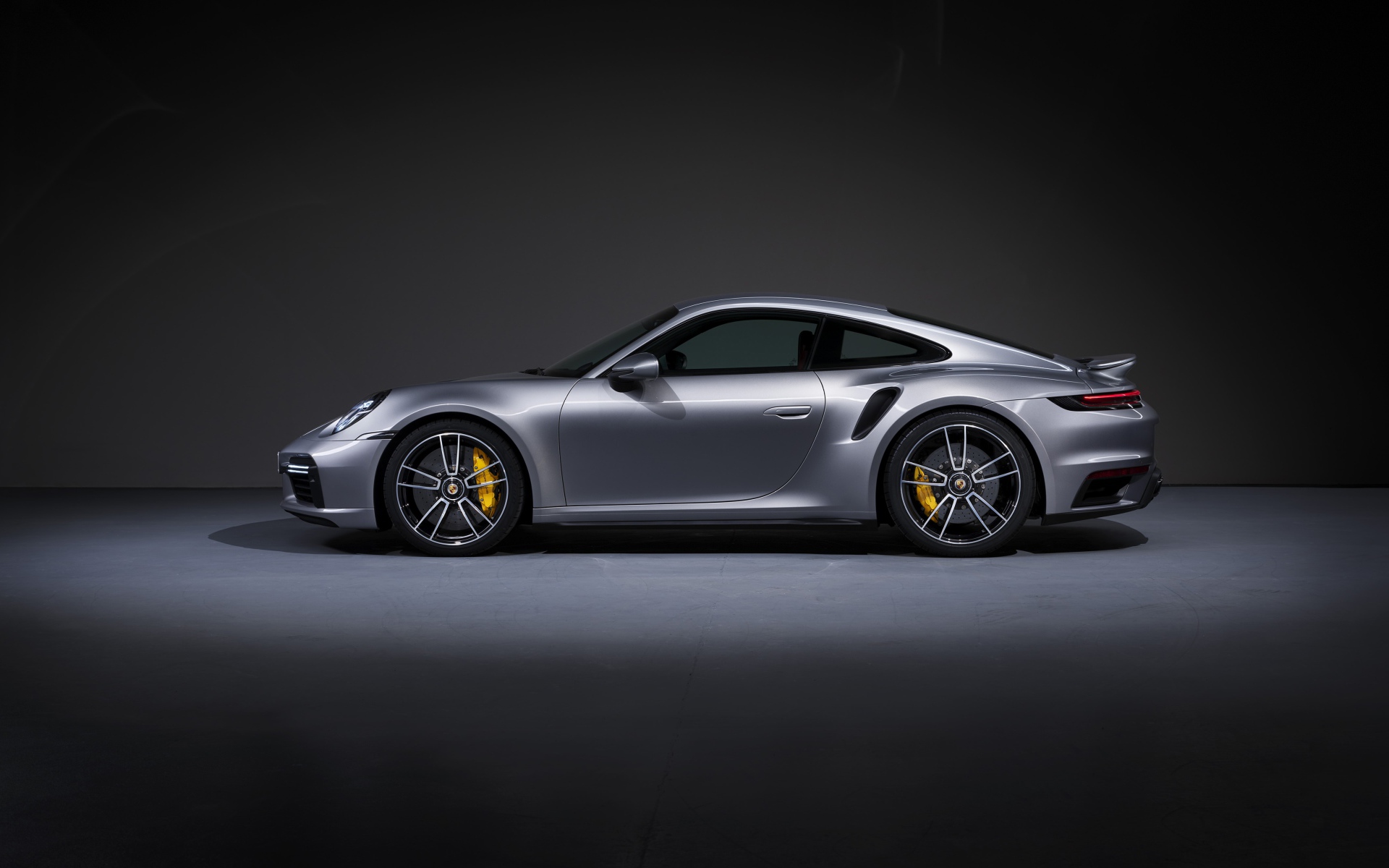 Серебристый автомобиль Porsche 911 Turbo S 2020 года вид сбоку 