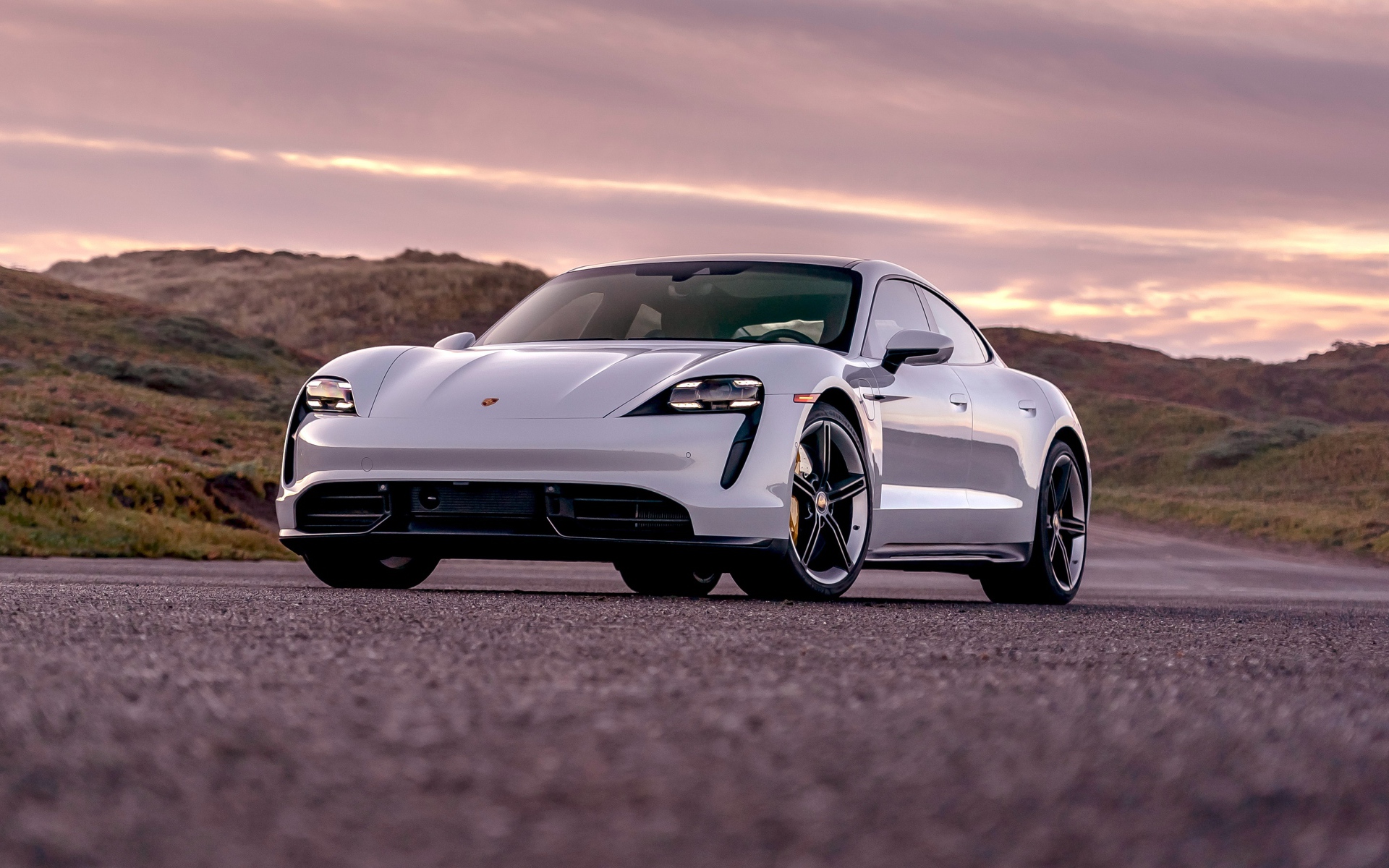 Серебристый автомобиль Porsche Taycan Turbo S 2020 года на фоне неба