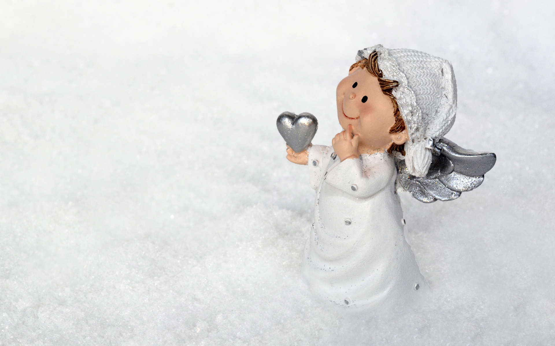 Статуэтка ангела стоит на снегу 