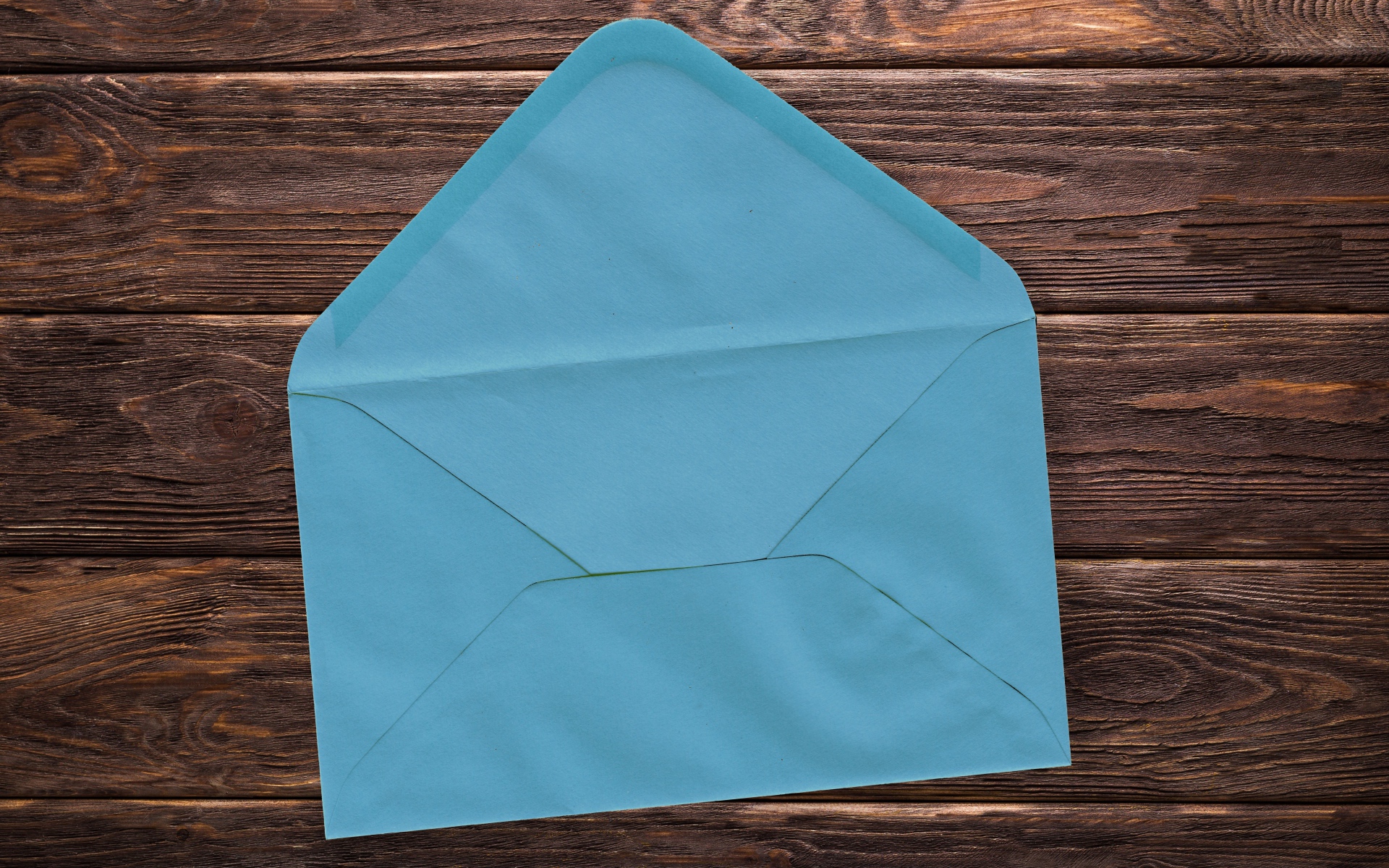 Голубой бумажный конверт на деревянном фоне