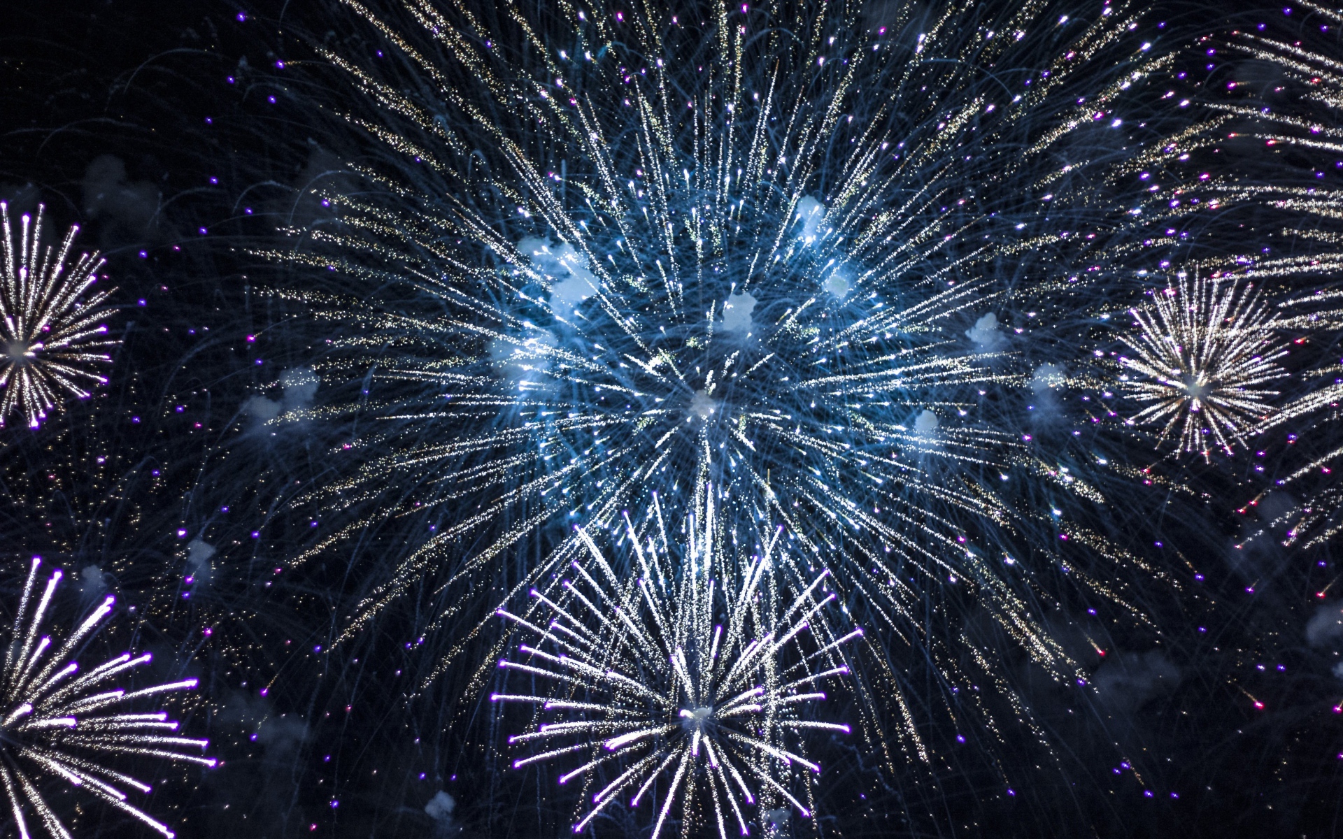 Яркие искры праздничного фейерверка  в ночном небе 