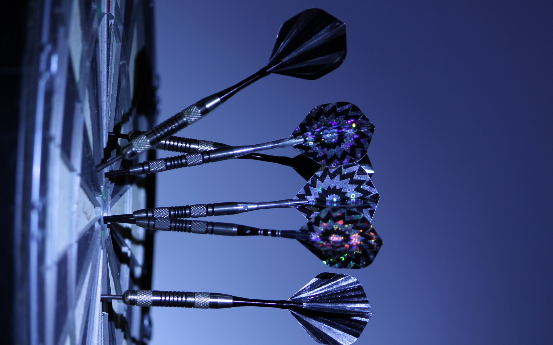 Дротики в доске для дартс на синем фоне 