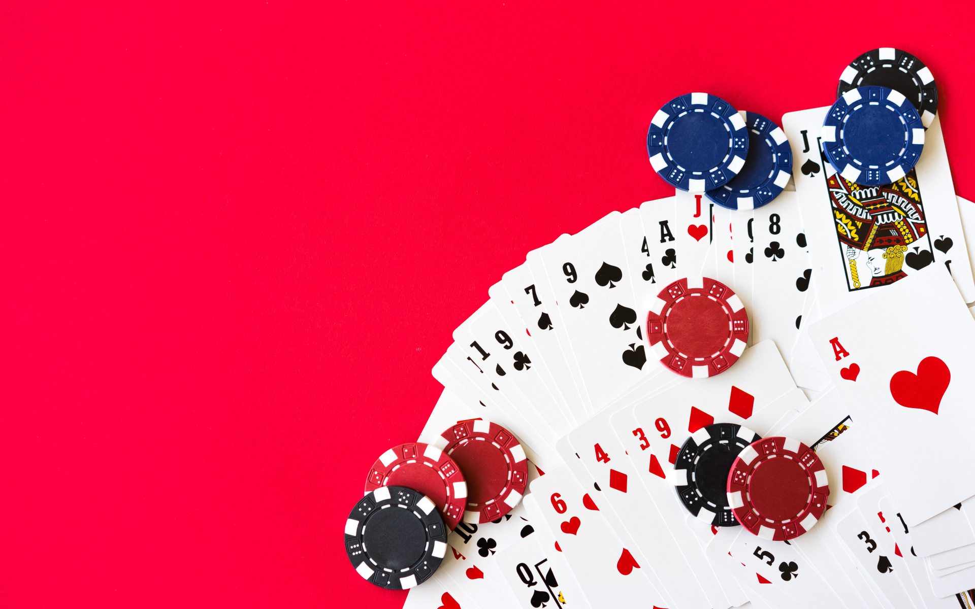 Deck of cards and poker chips on a red background