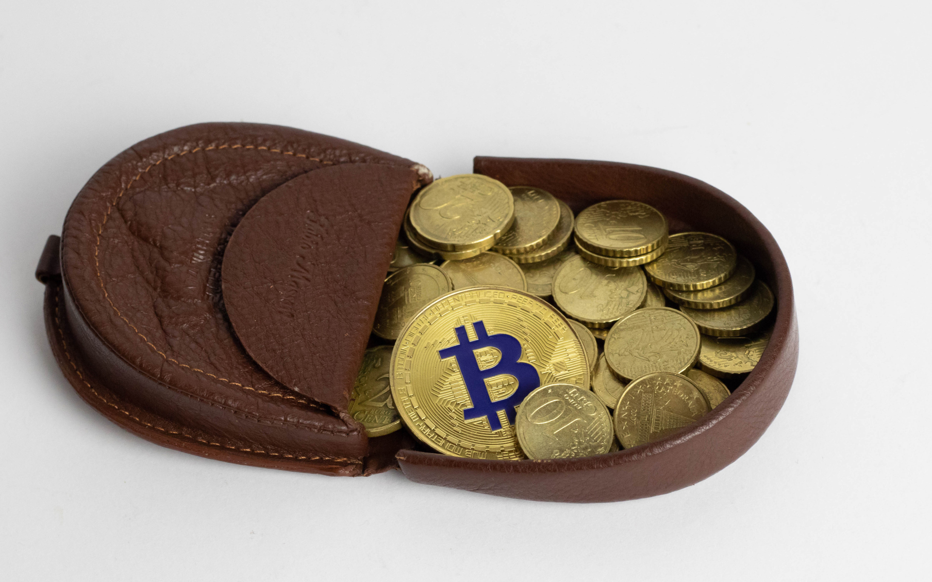 Кожаный кошелек с монетами на сером фоне