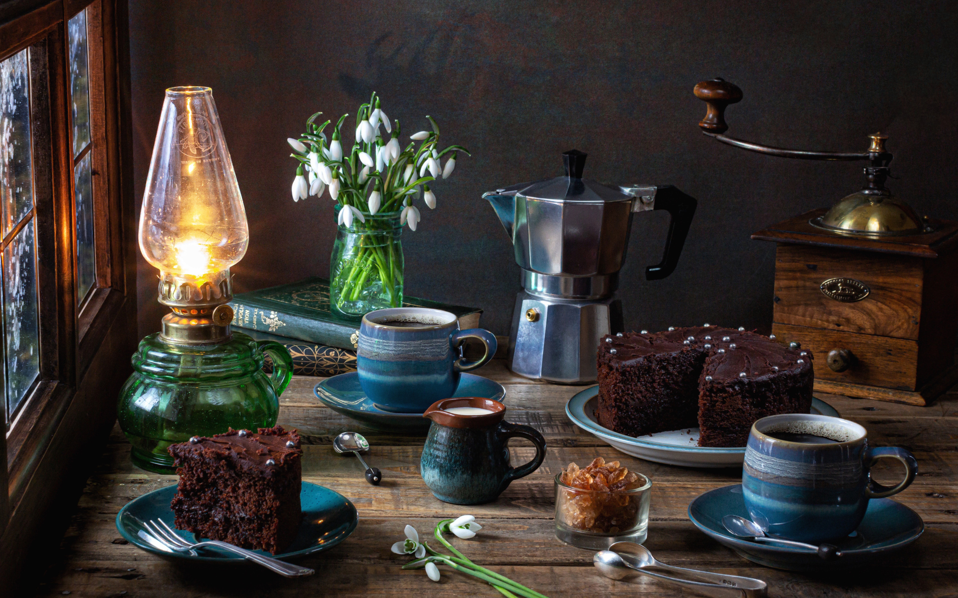 Шоколадный торт на столе с кофе, букетом подснежников и лампой