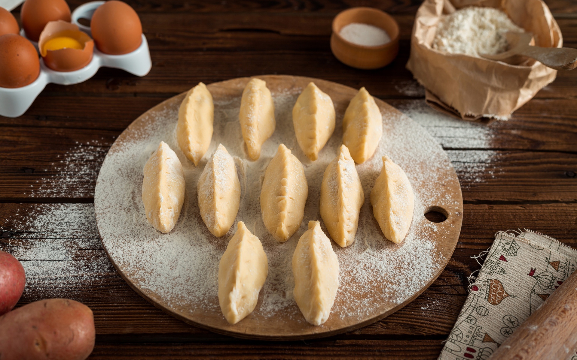 Вареники с картошкой на доске с мукой