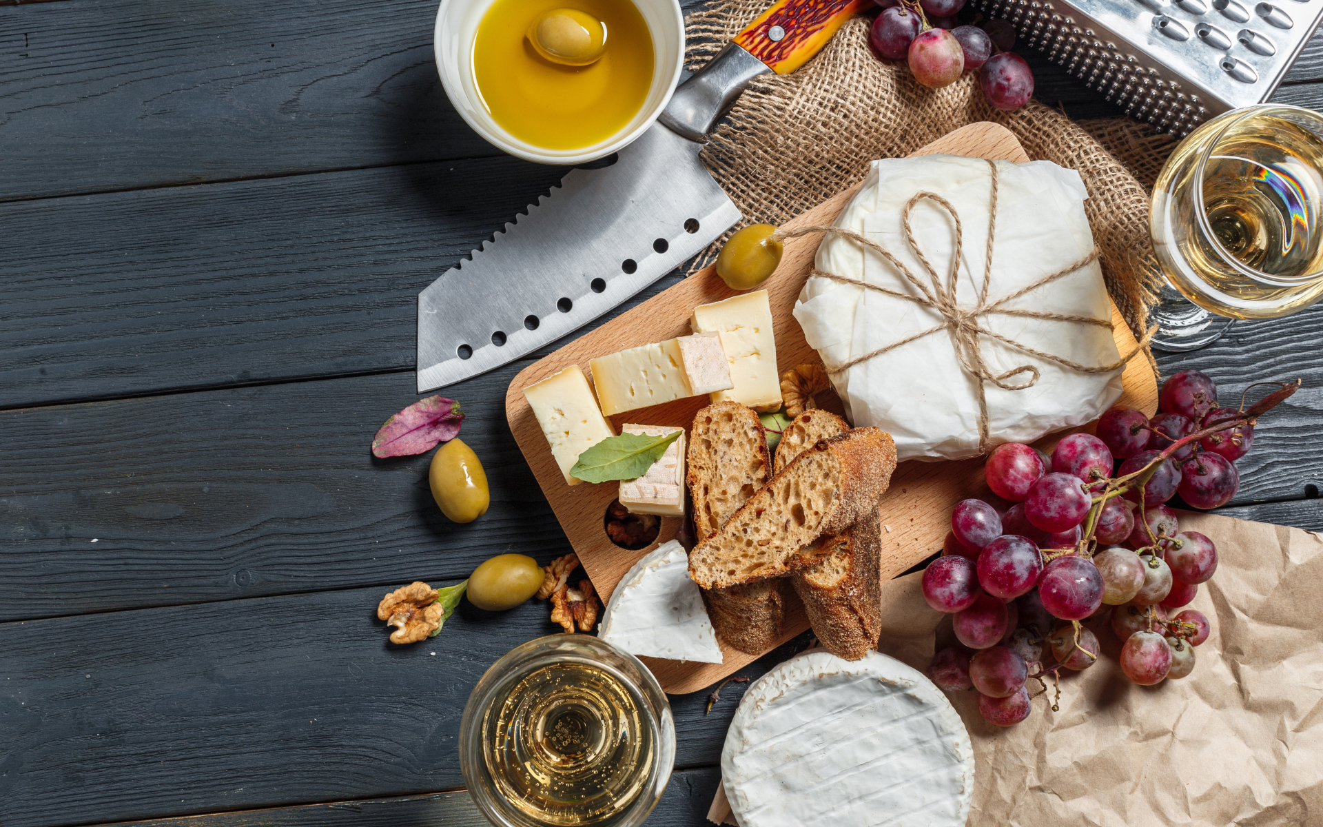 Виноград на столе с сыром, хлебом и оливками
