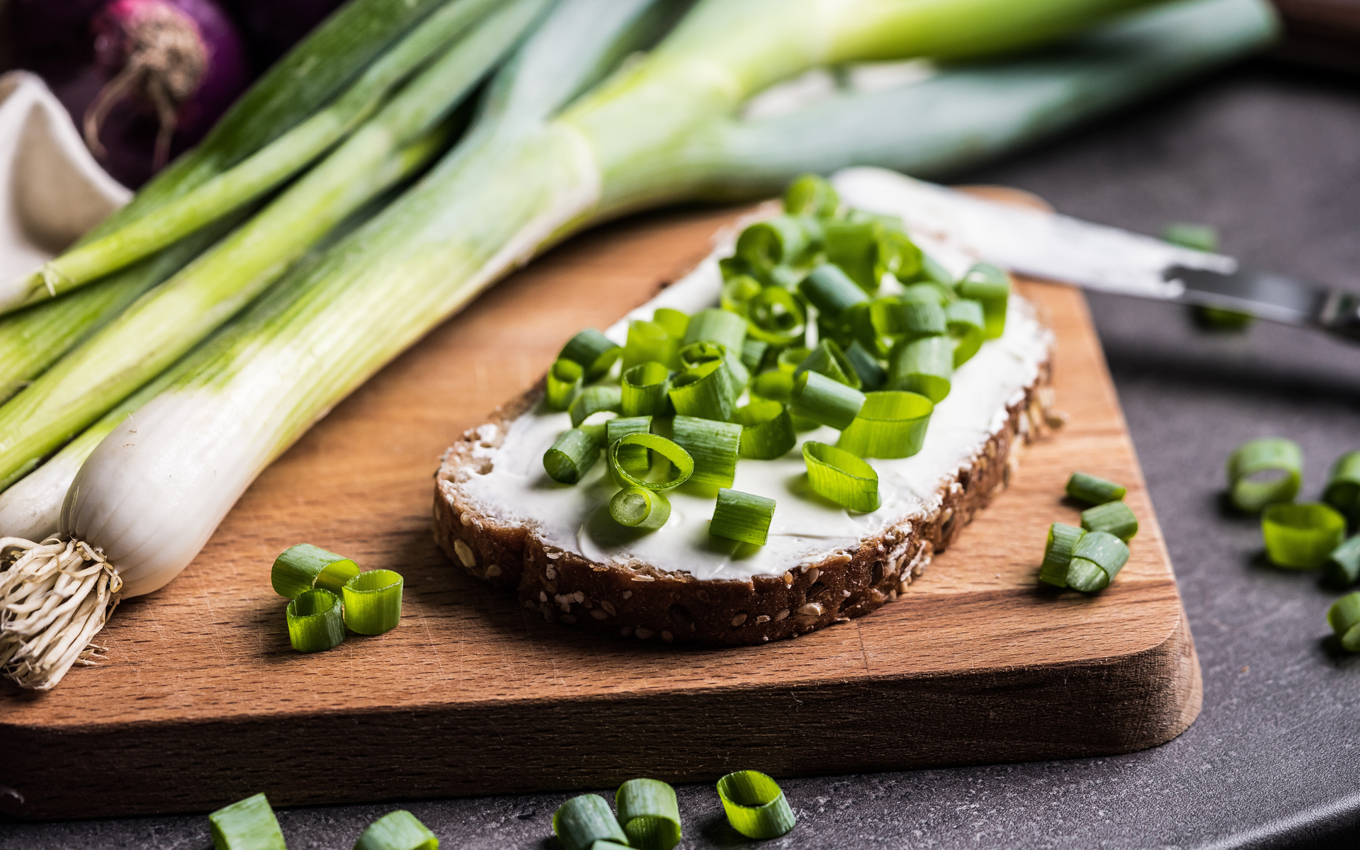 Бутерброд с маслом и зеленым луком на столе 