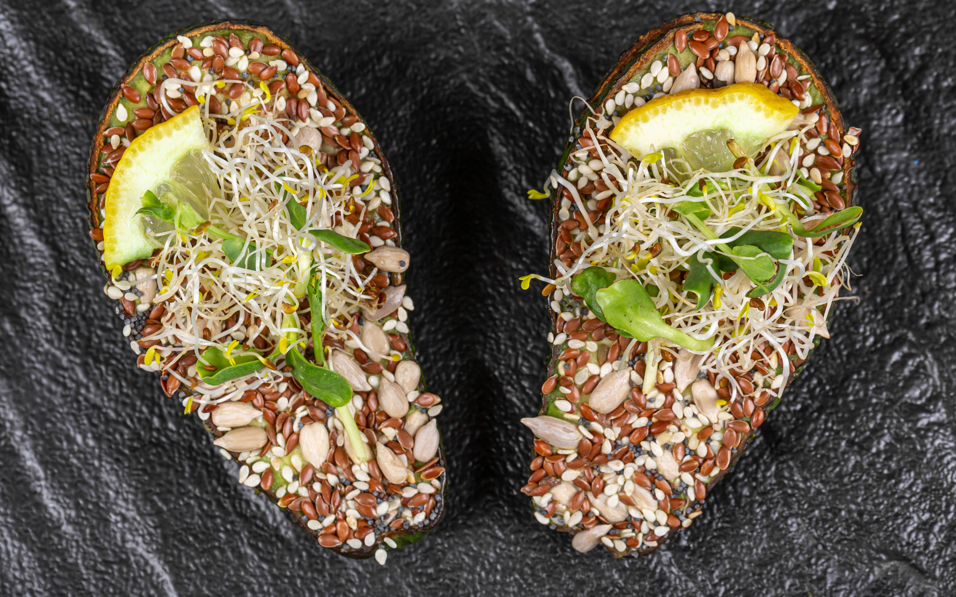 Половинки авокадо с проросшими зернами на столе