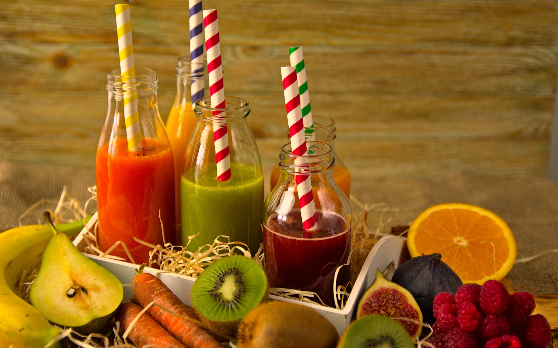 Бутылочки с соком на столе с фруктами 