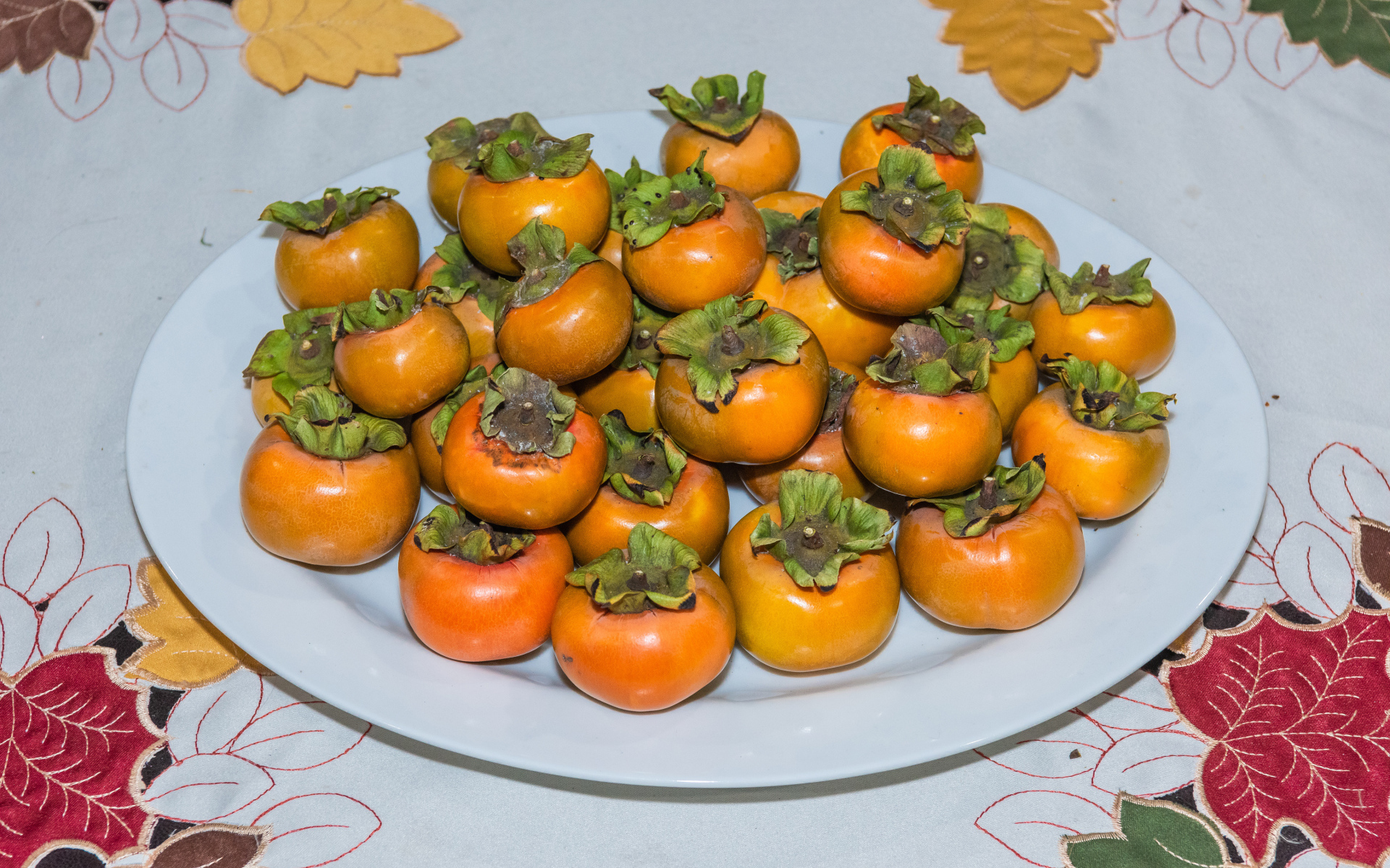 Спелый фрукт хурма на большой белой тарелке 