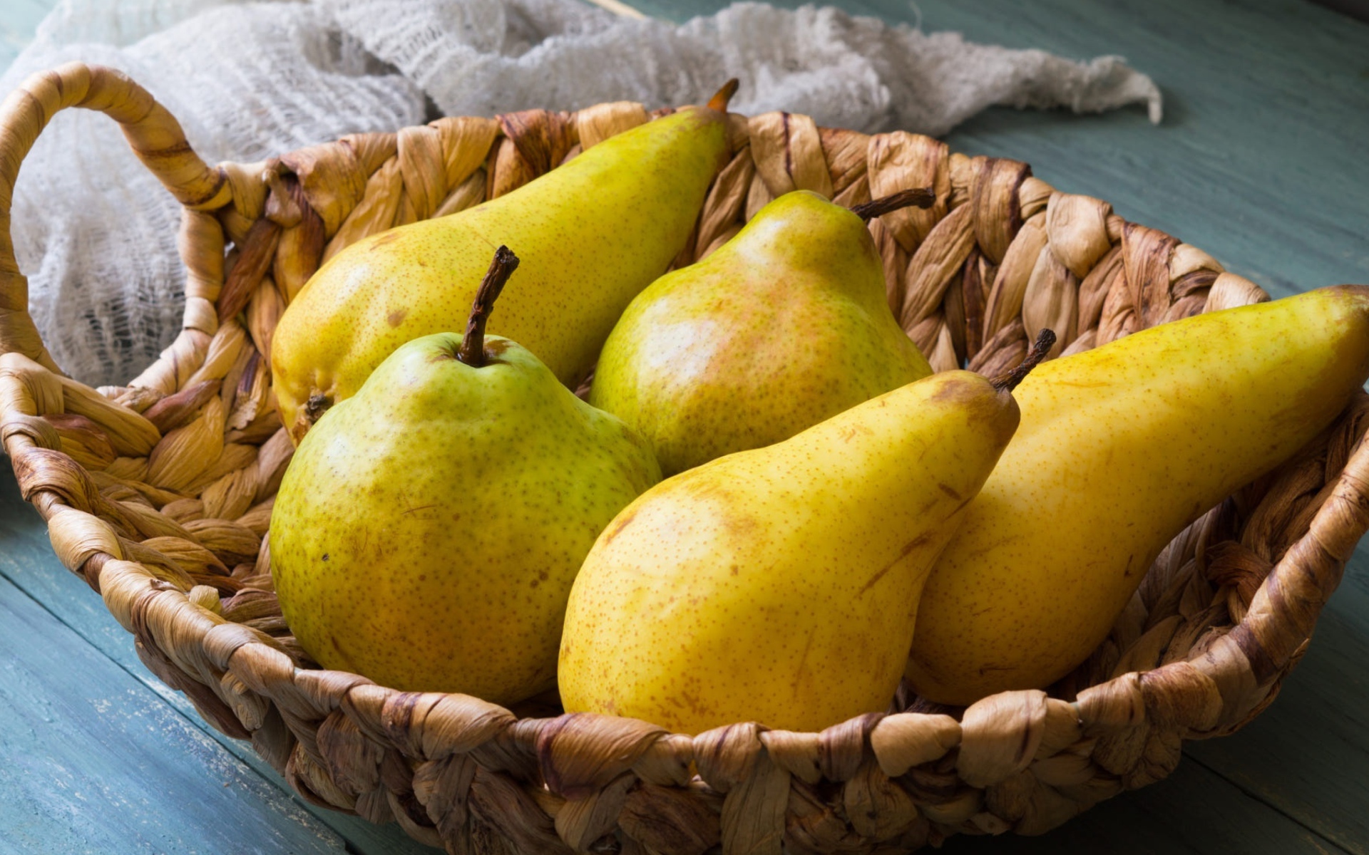 Спелые груши лежат в корзине на столе