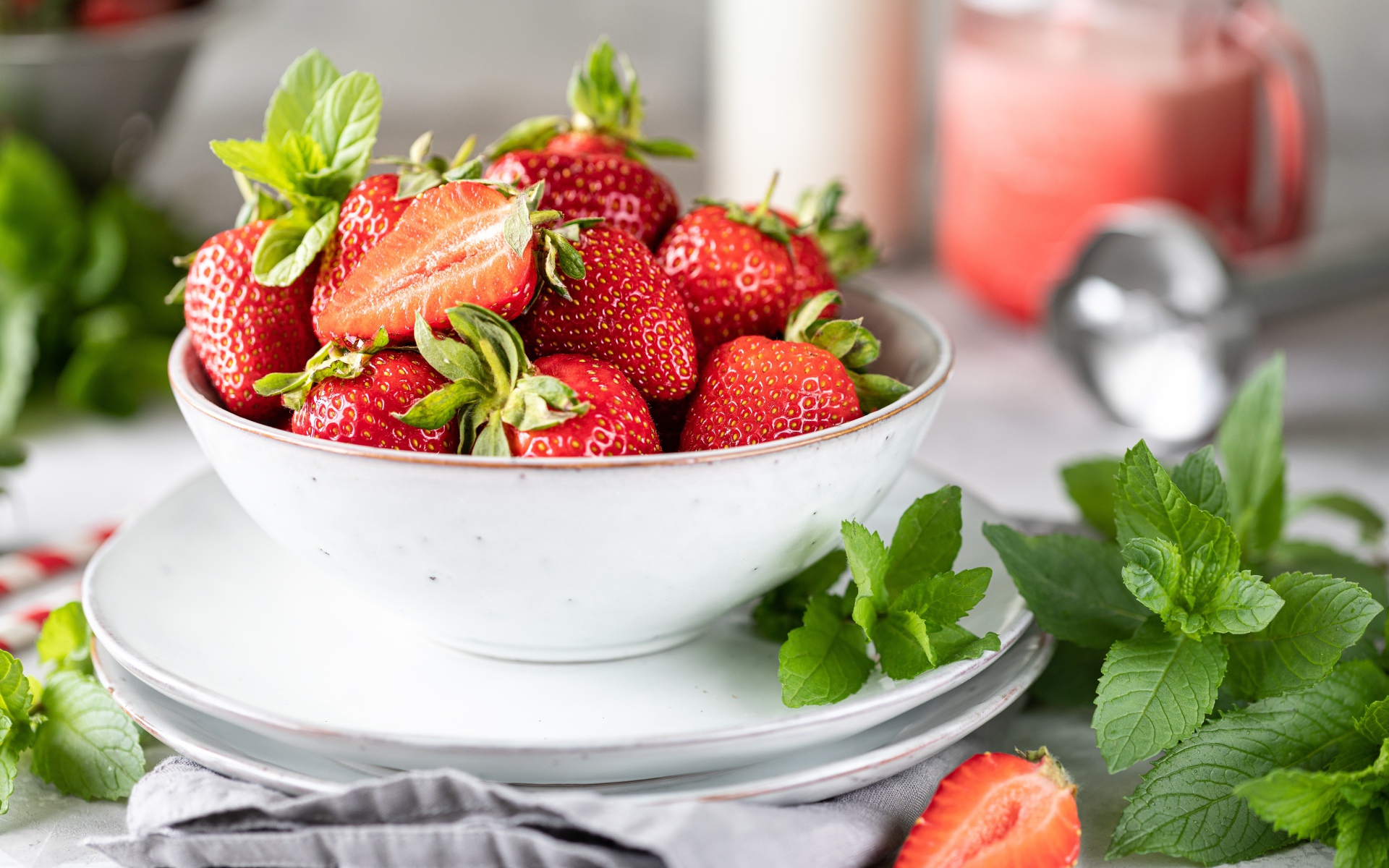 Спелая клубника с мятой на столе в белой тарелке 