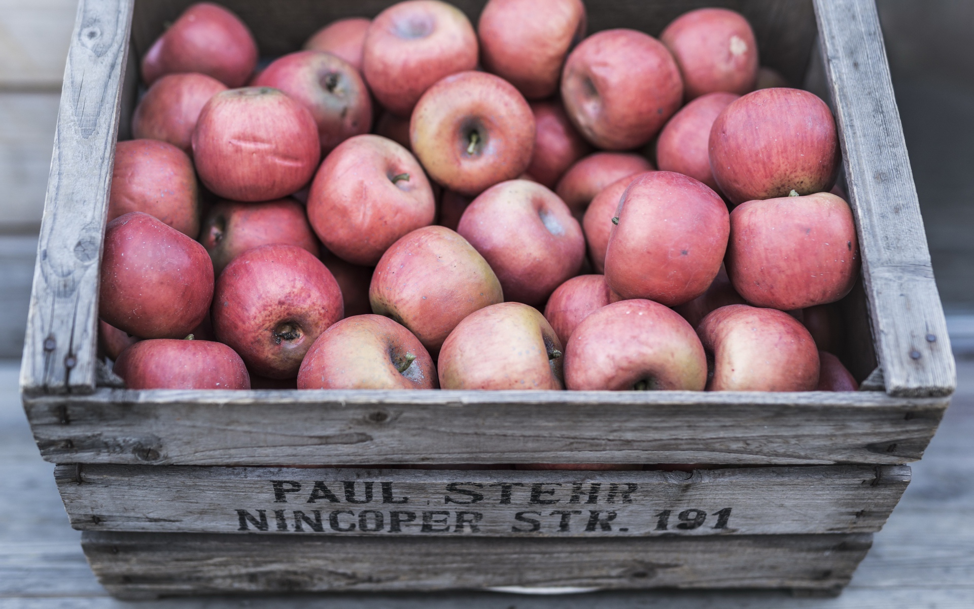 Деревянный ящик с красными спелыми яблоками