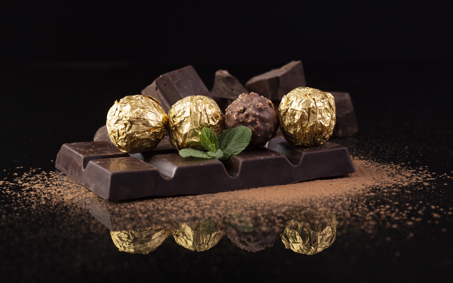Плитки черного шоколада с конфетами на столе 