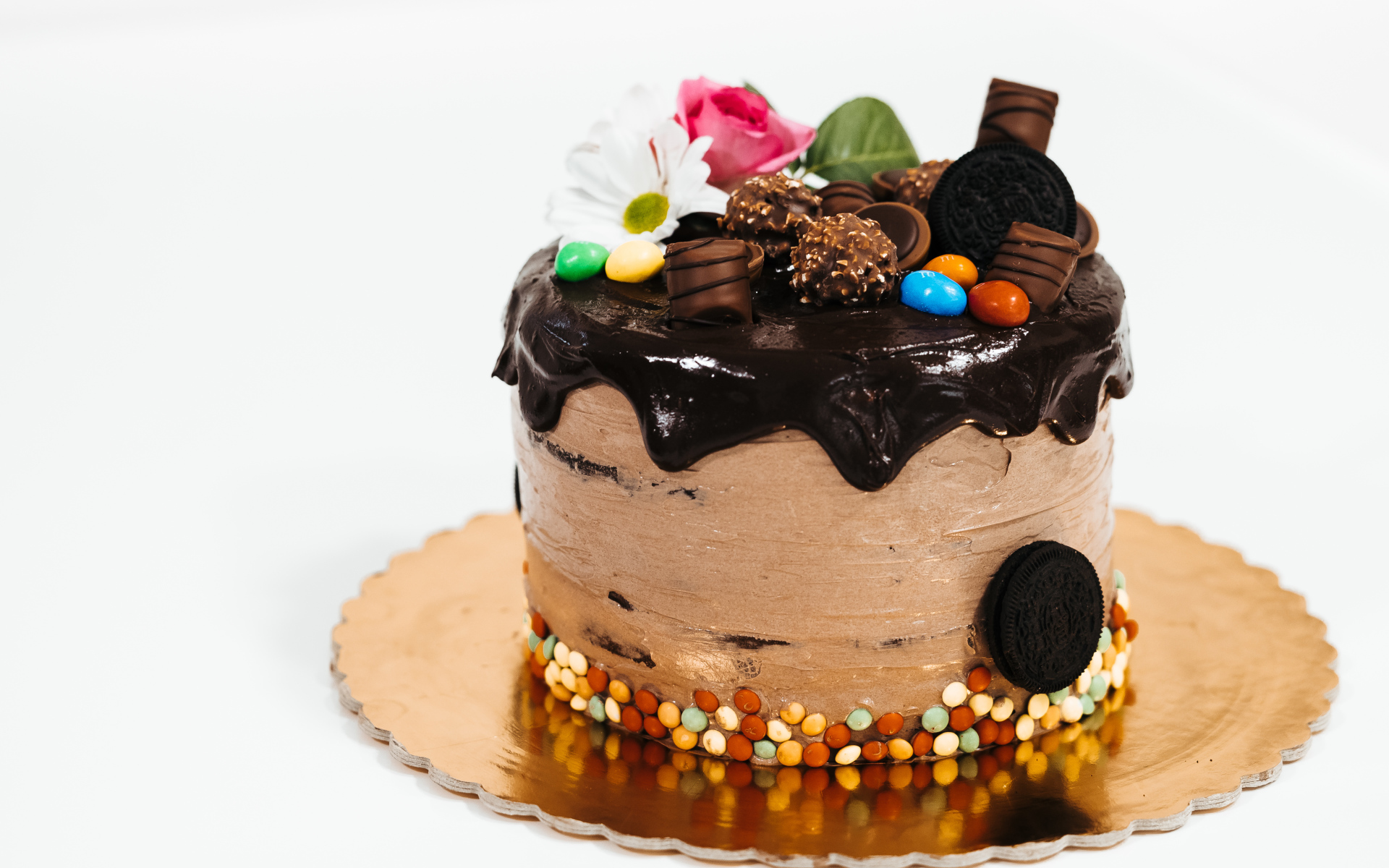 Торт с кремом и шоколадом украшен сладостями