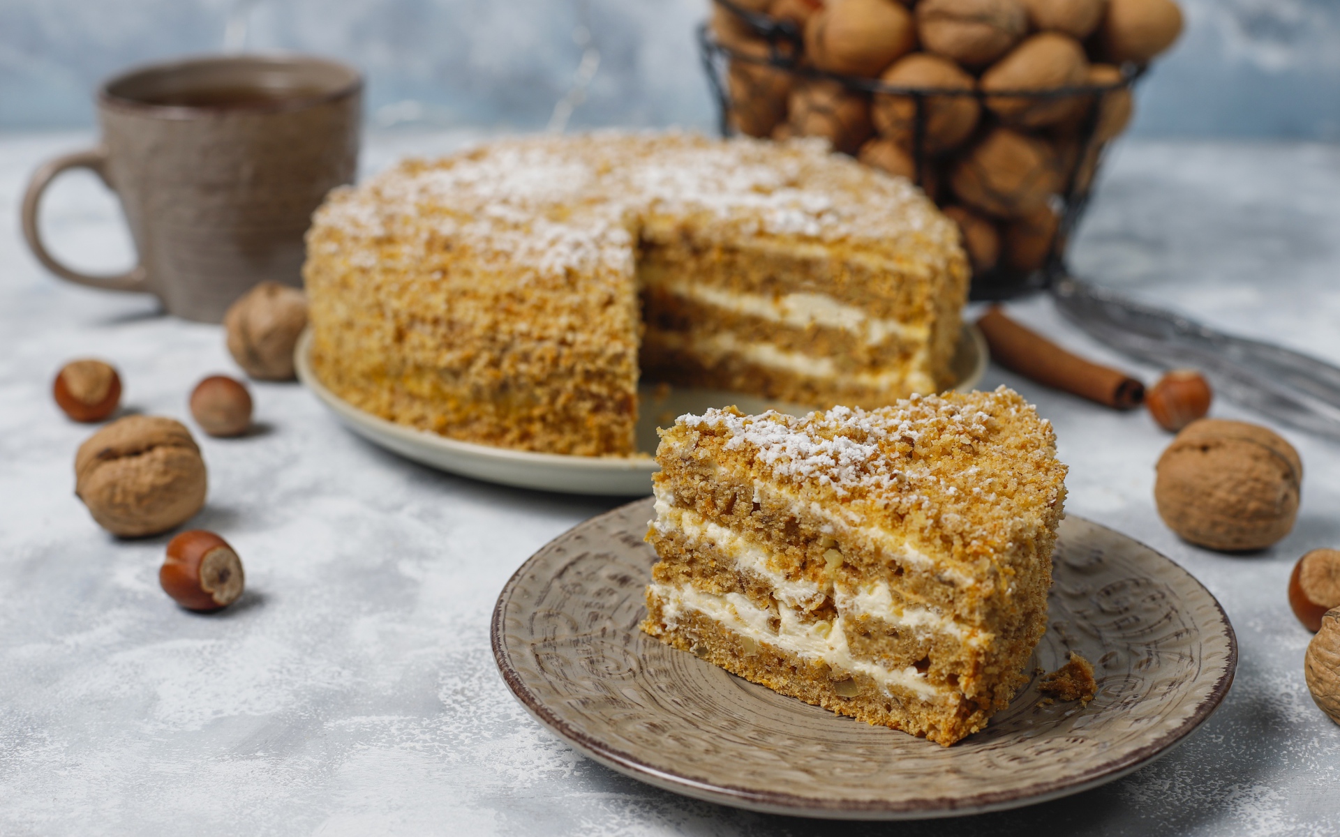 Торт медовик на столе с орехами и чашкой кофе