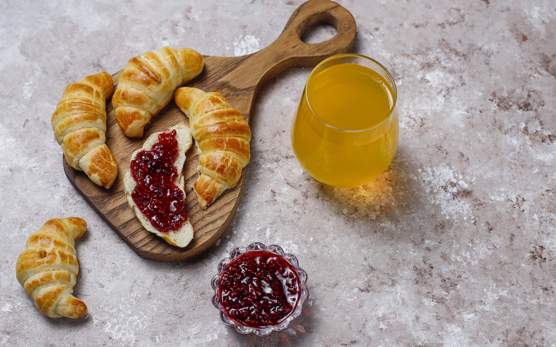 Сок на столе с круассанами и джемом